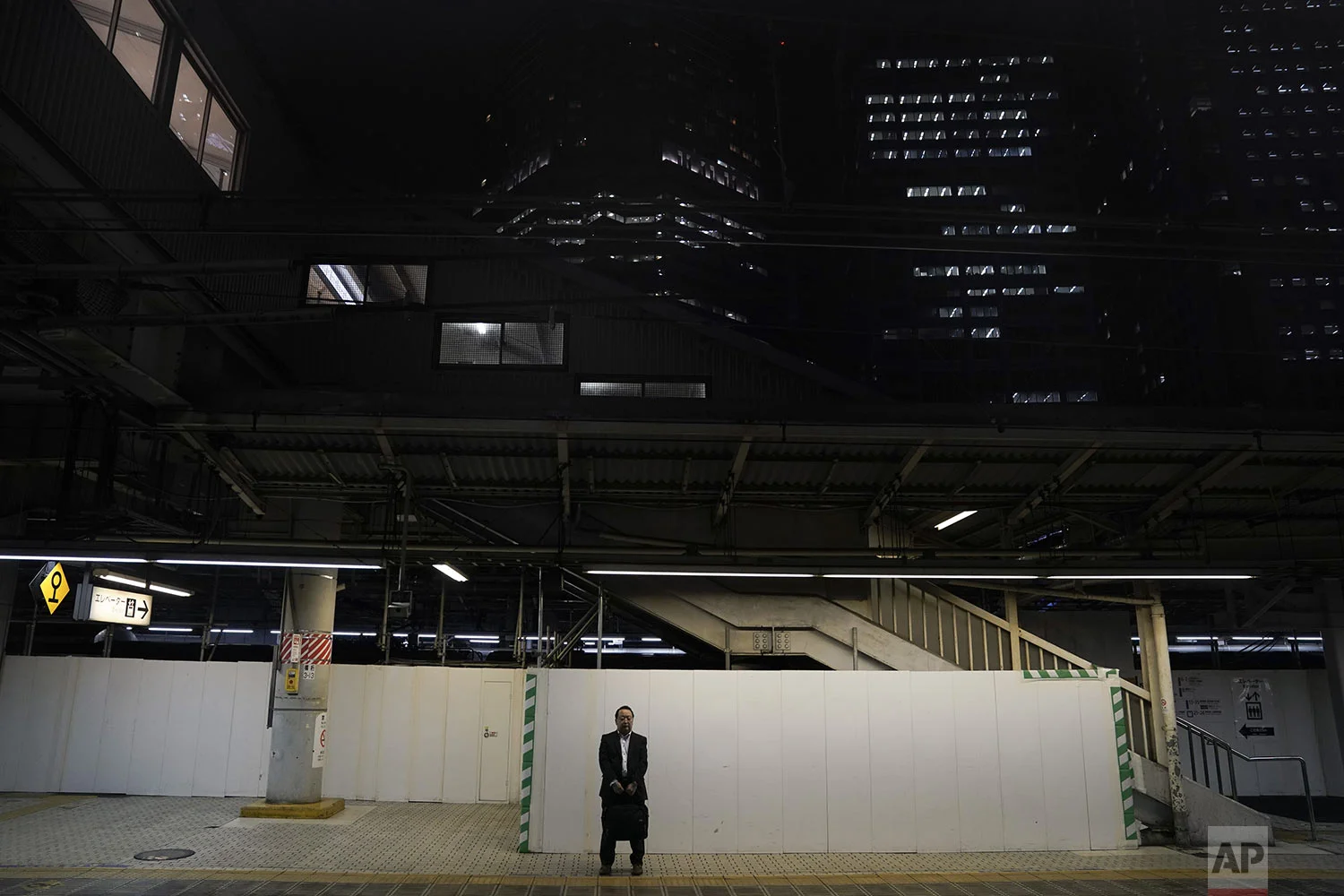 A man in a black suit waits for a train to arrive on a platform at Shinagawa Station in Tokyo, Tuesday, May 21, 2019. (AP Photo/Jae C. Hong)