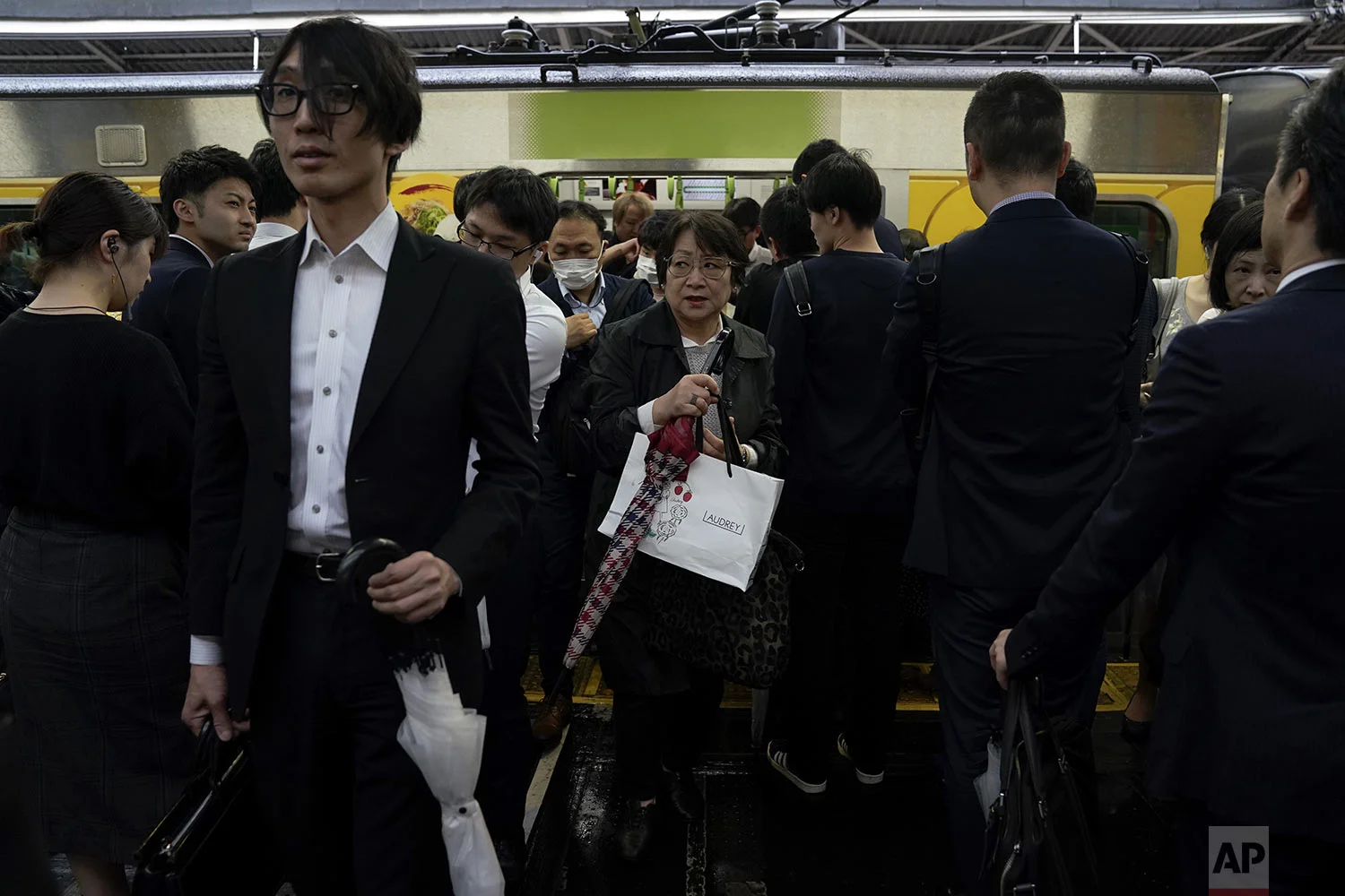 Commuters make their way past people waiting in line as they get off a Yamanote Line train during morning rush hours at Shinjuku Station in Tokyo, Tuesday, May 21, 2019. (AP Photo/Jae C. Hong)
