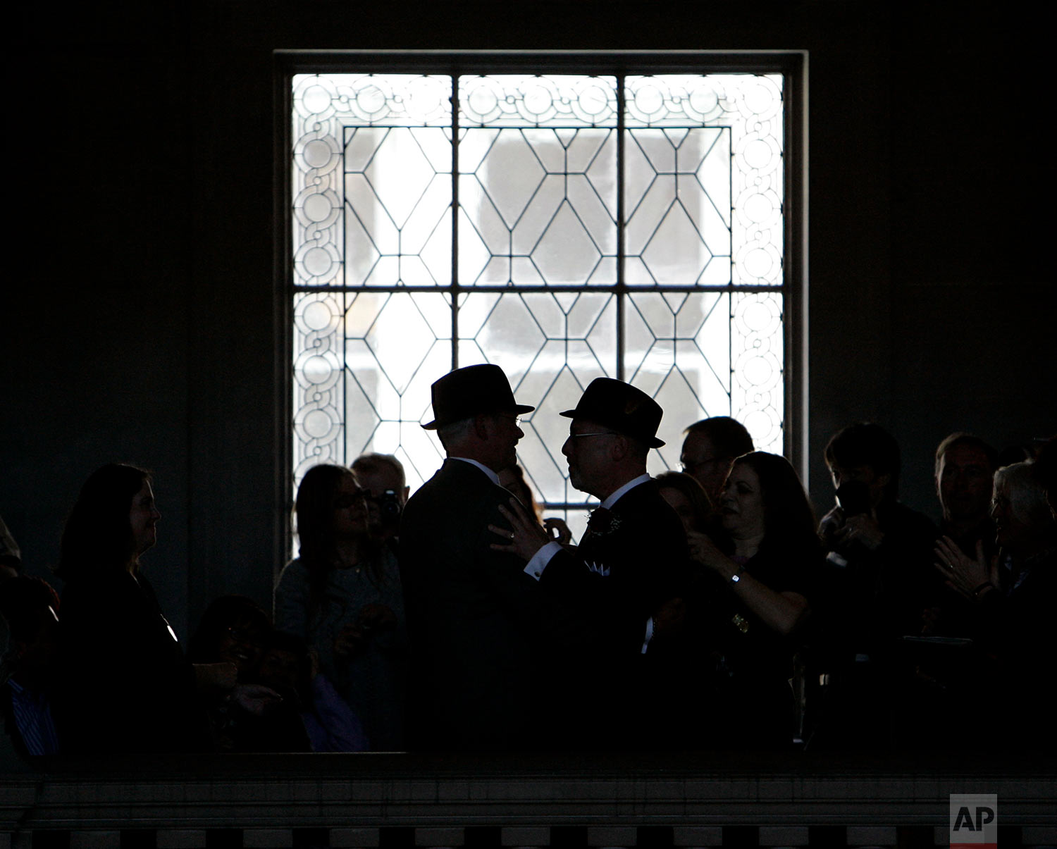 In this Tuesday, June 17, 2008 file photo, Curt Garman, left, and Richard Looke of Novato, Calif., wearing hats, embrace after being married at City Hall in San Francisco. County clerk offices across California opened for their first full day of same-sex marriages Tuesday, with hundreds of gay and lesbian couples ready to take the plunge in what in some cities was a party atmosphere. (AP Photo/Eric Risberg)