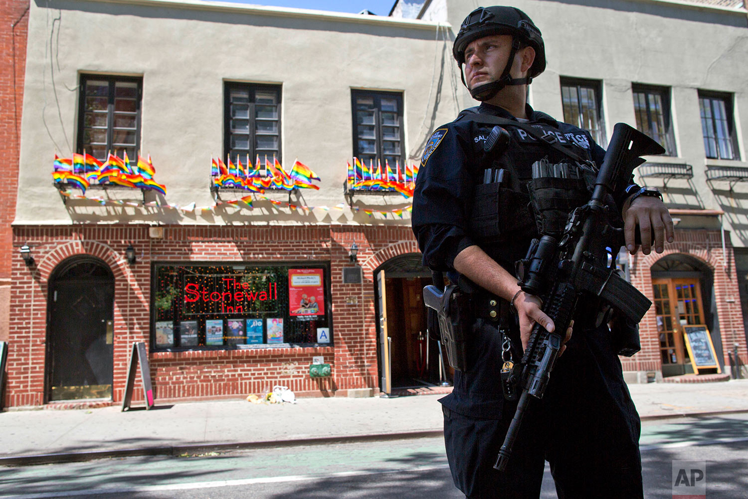 In this June 12, 2016 file photo, an armed police officer stands guard outside the Stonewall Inn in New York, after a gunman in Orlando, Fla., opened fire in a gay nightclub, spreading fear of more attacks. (AP Photo/Mary Altaffer)