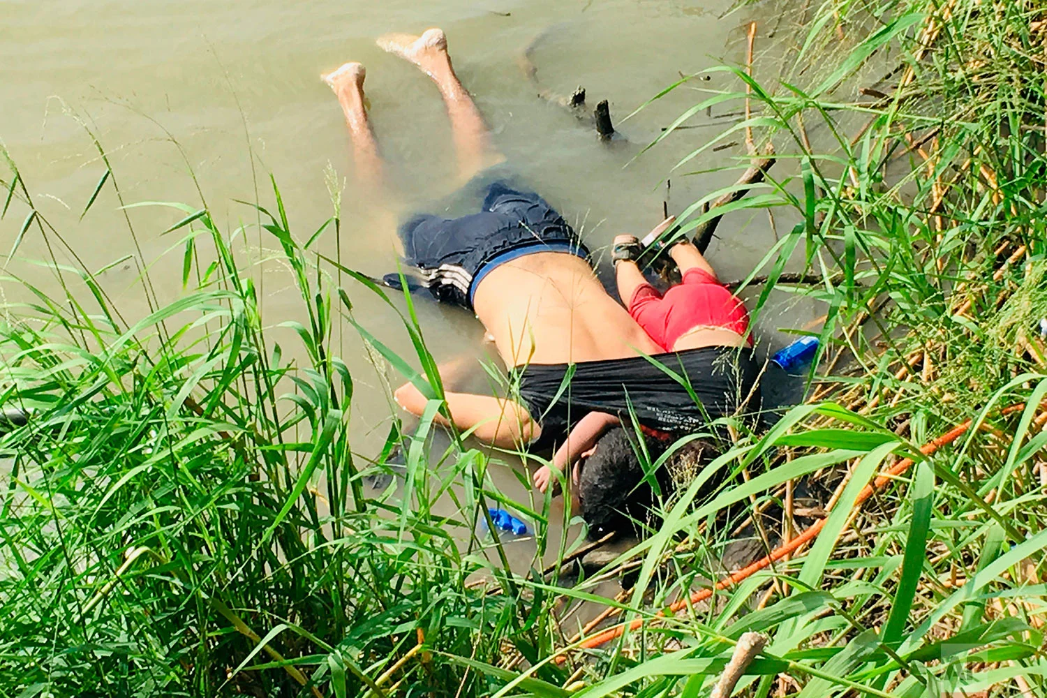 The bodies of Salvadoran migrant Oscar Alberto Martínez Ramírez and his nearly 2-year-old daughter Valeria lie on the bank of the Rio Grande in Matamoros, Mexico, Monday, June 24, 2019, after they drowned trying to cross the river to Brownsville, Texas. (AP Photo/Julia Le Duc)