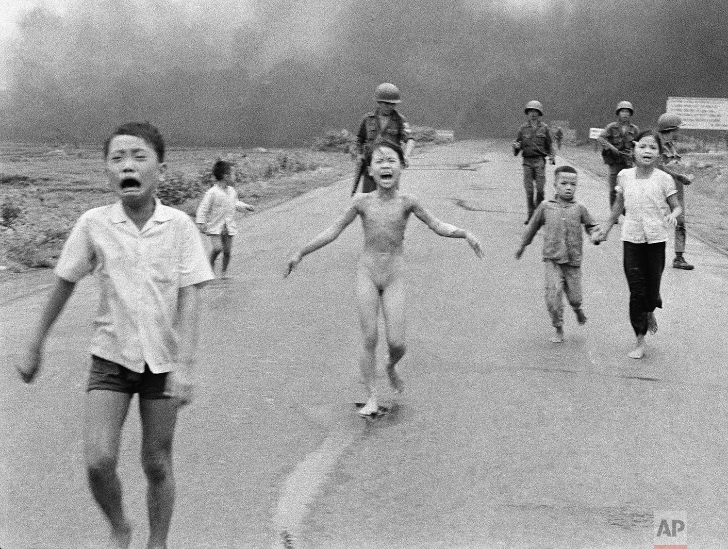 South Vietnamese forces follow after terrified children, including 9-year-old Kim Phuc, center, as they run down Route 1 near Trang Bang after an aerial napalm attack on suspected Viet Cong hiding places on June 8, 1972. (AP Photo/Nick Ut)