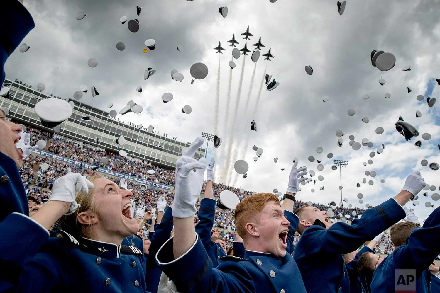 United States Air Force Academy cadets toss their hats in the air as the Thunderbirds fly overhead during the cadets' graduation ceremony at Falcon Stadium., Thursday, May 30, 2019, in Colorado Springs, Colo. (AP Photo/Andrew Harnik)