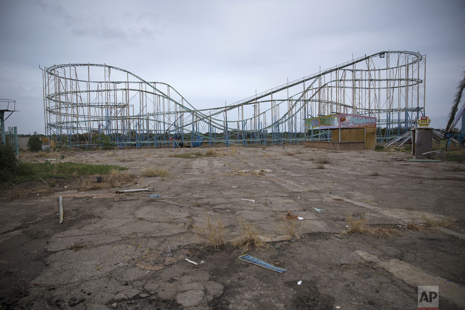 A roller coaster stands tall in the abandoned amusement park coined "Diversions Grano de Oro" in Maracaibo, Venezuela, May 23, 2019. Much of Venezuela is in a state of decay and abandonment, brought on by shortages of things that people need the most: cash, food, water, medicine, power, gasoline. (AP Photo/Rodrigo Abd)