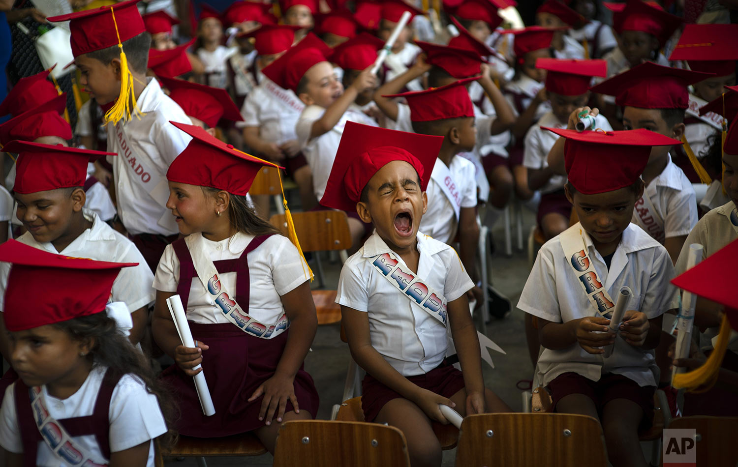A child yawns during his kindergarten graduation ceremony in Havana, Cuba, Friday, June 21, 2019. (AP Photo/Ramon Espinosa)