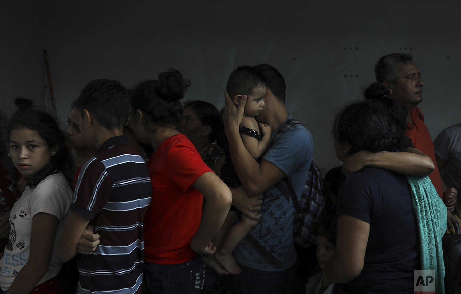 Detained migrants stand together in a storage room at the back of the Azteca Hotel where they tried to hide from Mexican immigration agents conducting a raid in Veracruz, Mexico, Thursday, June 27, 2019. Under increasing U.S. pressure to reduce the flow of hundreds of thousands of Central Americans through Mexican territory, Mexico's government has stepped up enforcement. (AP Photo/Felix Marquez)