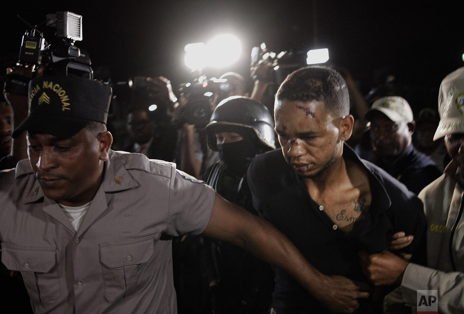 Eddy Vladimir Feliz Garcia, in custody in connection with the shooting of former Boston Red Sox slugger David Ortiz, is transferred by police to court in Santo Domingo, Dominican Republic, Tuesday, June 11, 2019. His lawyer Deivi Solano said Feliz Garcia had no idea who he'd picked up and what was about to happen, and that he expected Feliz Garcia would be charged as an accomplice to an attempted murder. (AP Photo/Roberto Guzman)
