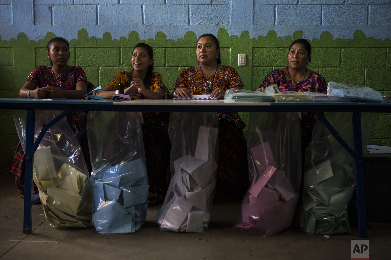 Electoral workers wait for people to cast their votes during general elections in Chinautla on the outskirts of Guatemala City, Sunday, June 16, 2019. Guatemalans are voting for their next president in elections plagued by widespread disillusion and distrust, and as thousands of their compatriots flee poverty and gang violence to seek a new life in the United States. (AP Photo/Oliver de Ros)