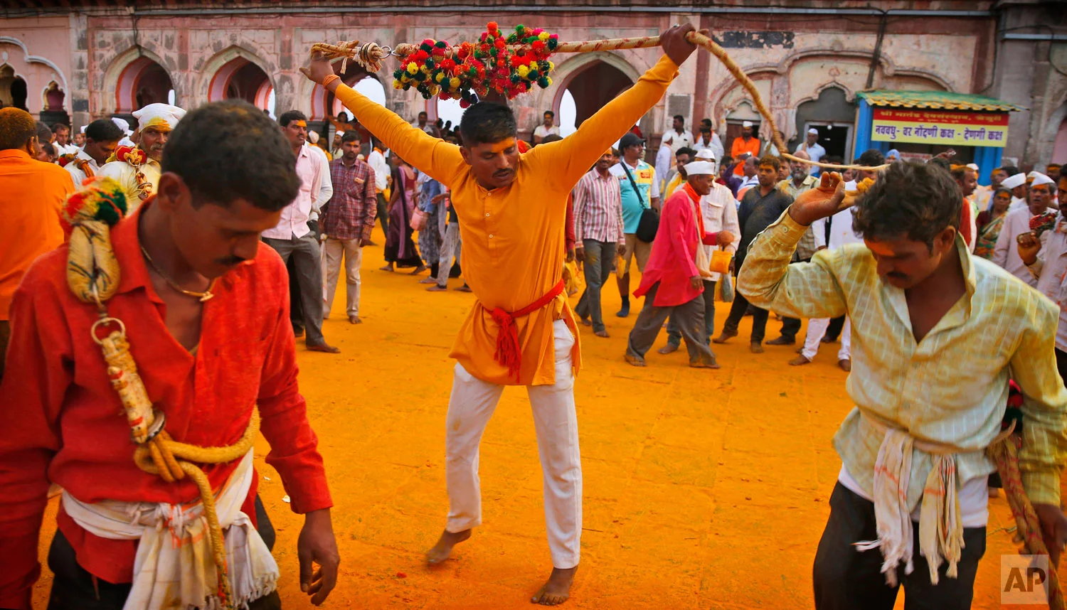 In this Monday, June 3, 2019, photo, devotees perform rituals during the celebration of the Bhandara Festival, or the Festival of Turmeric, at the Jejuri temple in Pune district, Maharashtra state, India. During the festival, devotees use the golden