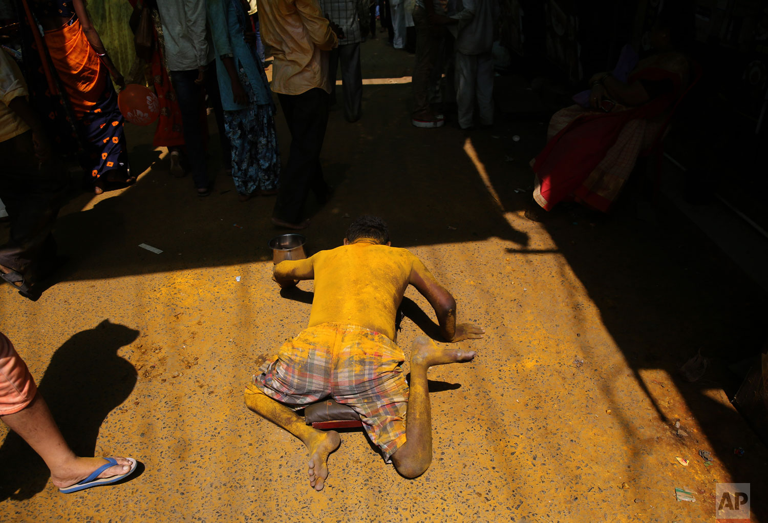 A bigger begs outside a temple during the celebration of the Bhandara Festival, or the Festival of Turmeric, at the Jejuri temple in Pune district, Maharashtra state, India. During the festival, devotees use the golden powder to worship the deity Lord Khandoba, widely known as a descendant of the sun, and to celebrate his victory over the demons Mani and Malla. (AP Photo/Rafiq Maqbool)