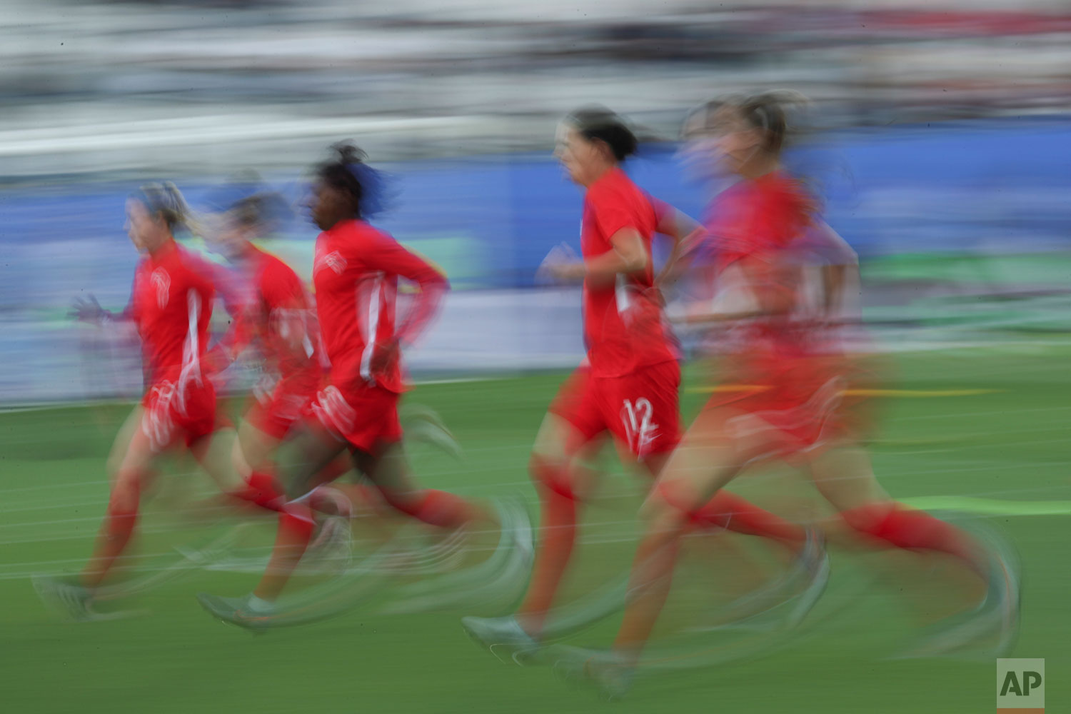 In this image taken with a slow shutter speed Canadian players warm up before the start of the Women's World Cup Group E soccer match between Canada and New Zealand in Grenoble, France, Saturday, June 15, 2019. (AP Photo/Francisco Seco)