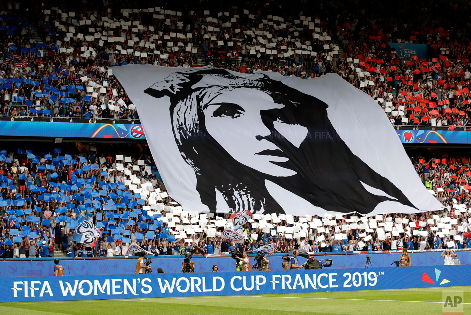 French fans hold a banner that shows Marianne, personification of the French Republic, prior the Women's World Cup quarterfinal soccer match between France and the United States at the Parc des Princes, in Paris, Friday, June 28, 2019.(AP Photo/Alessandra Tarantino)