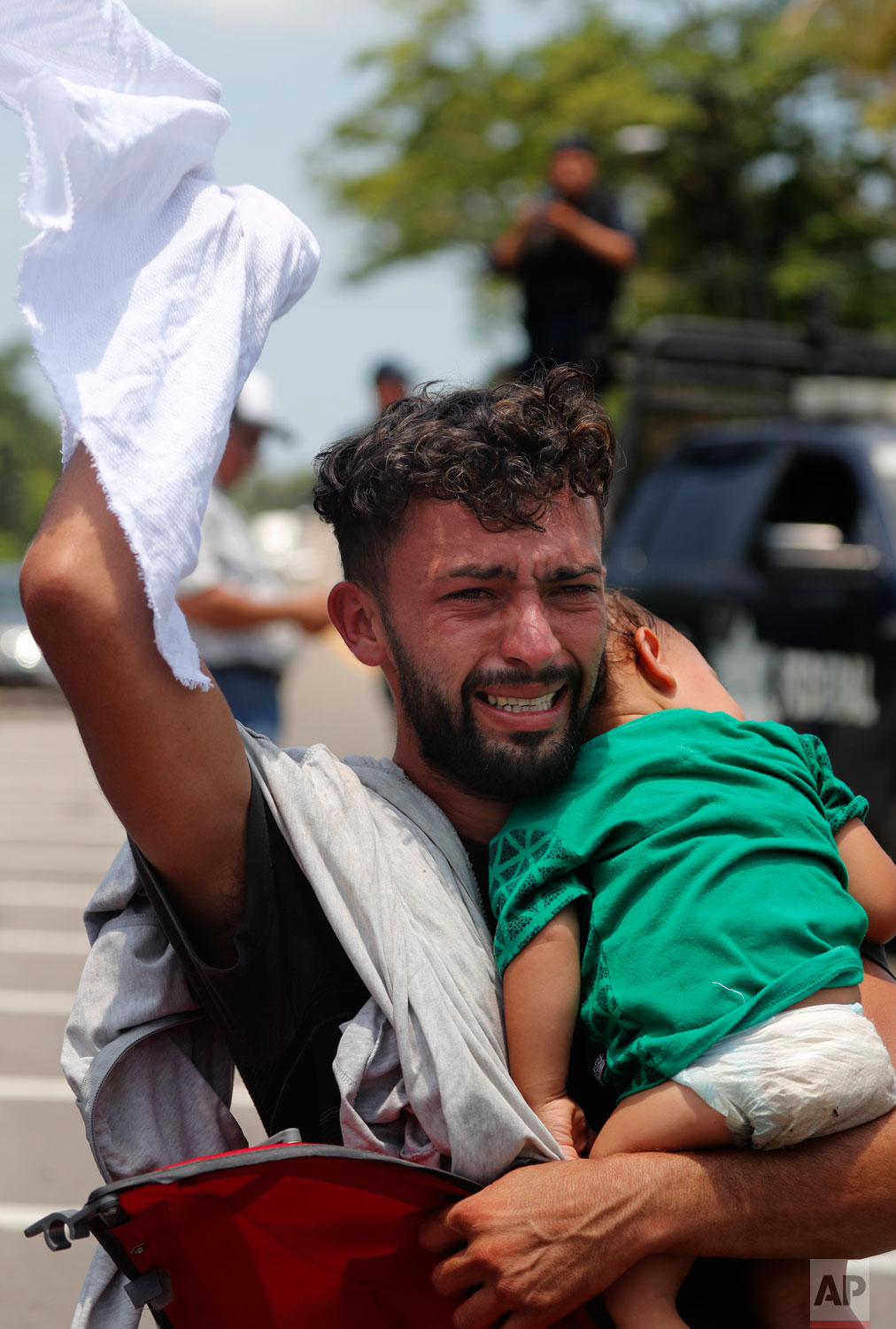 A man begs and prays not to be taken away by Mexican immigration authorities as he holds his child, during a raid on a migrant caravan that had earlier crossed the Mexico - Guatemala border, near Metapa, Chiapas state, Mexico, Wednesday, June 5, 2019. (AP Photo/Marco Ugarte)