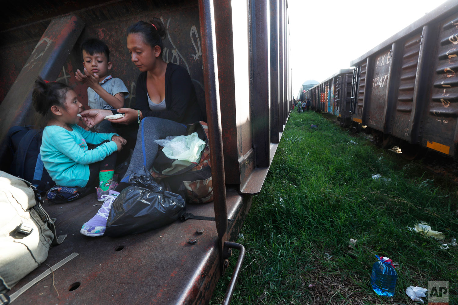 A migrant mother and children ride a freight train on their way north, in Palenque, Chiapas state, Mexico, Monday, June 24, 2019. (AP Photo/Marco Ugarte)