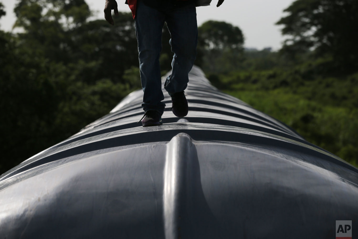 A Honduran migrant ride a freight train on their way north, in Salto del Agua, Chiapas state, Mexico, Tuesday, June 25, 2019. (AP Photo/Marco Ugarte)