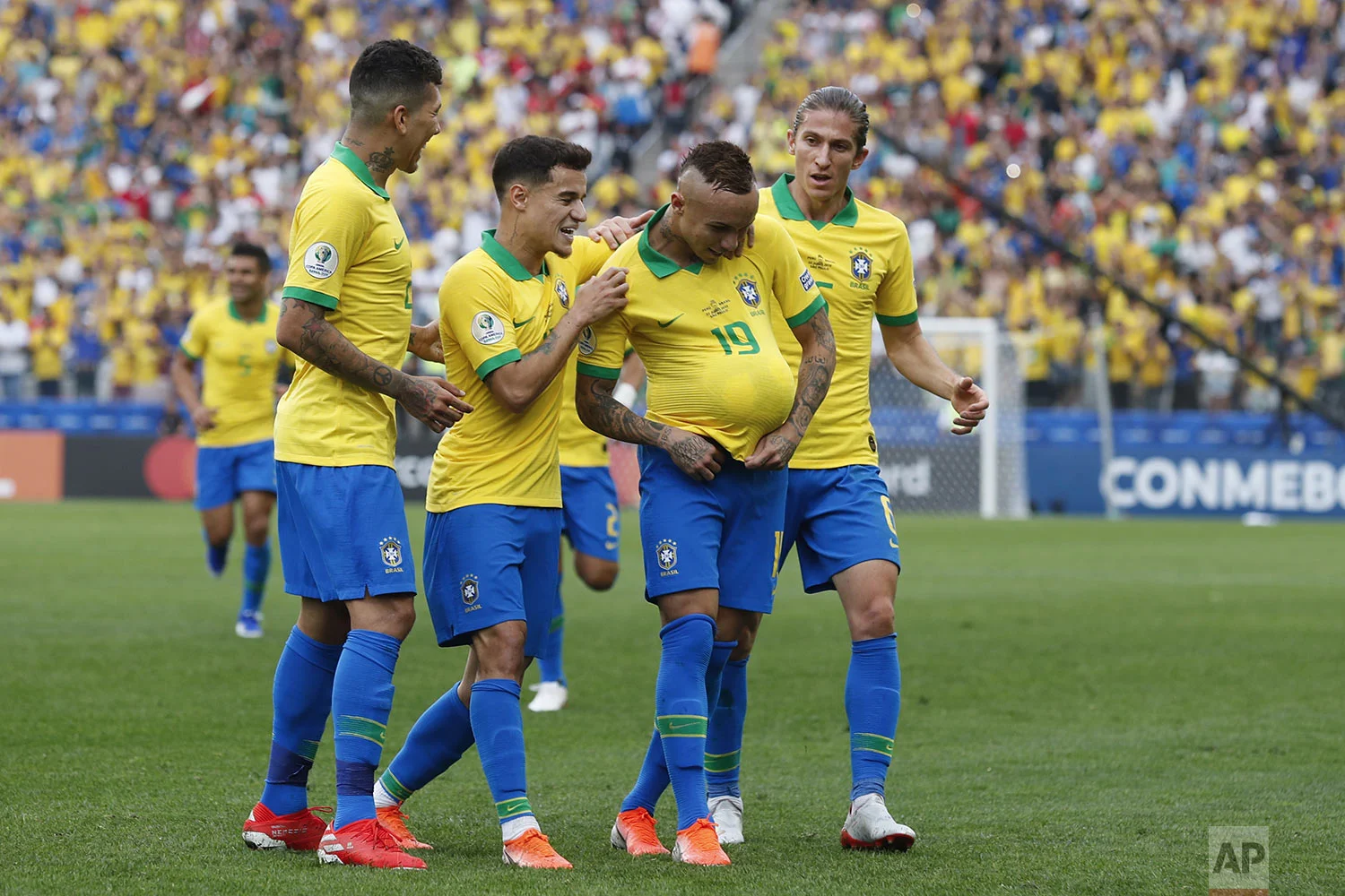 Brazil players congratulate teammate Everton, with the ball under his jersey, after he scored his side's third goal against Peru during a Copa America Group A soccer match at Arena Corinthians in Sao Paulo, Brazil, Saturday, June 22, 2019. (AP Photo/Victor R. Caivano)