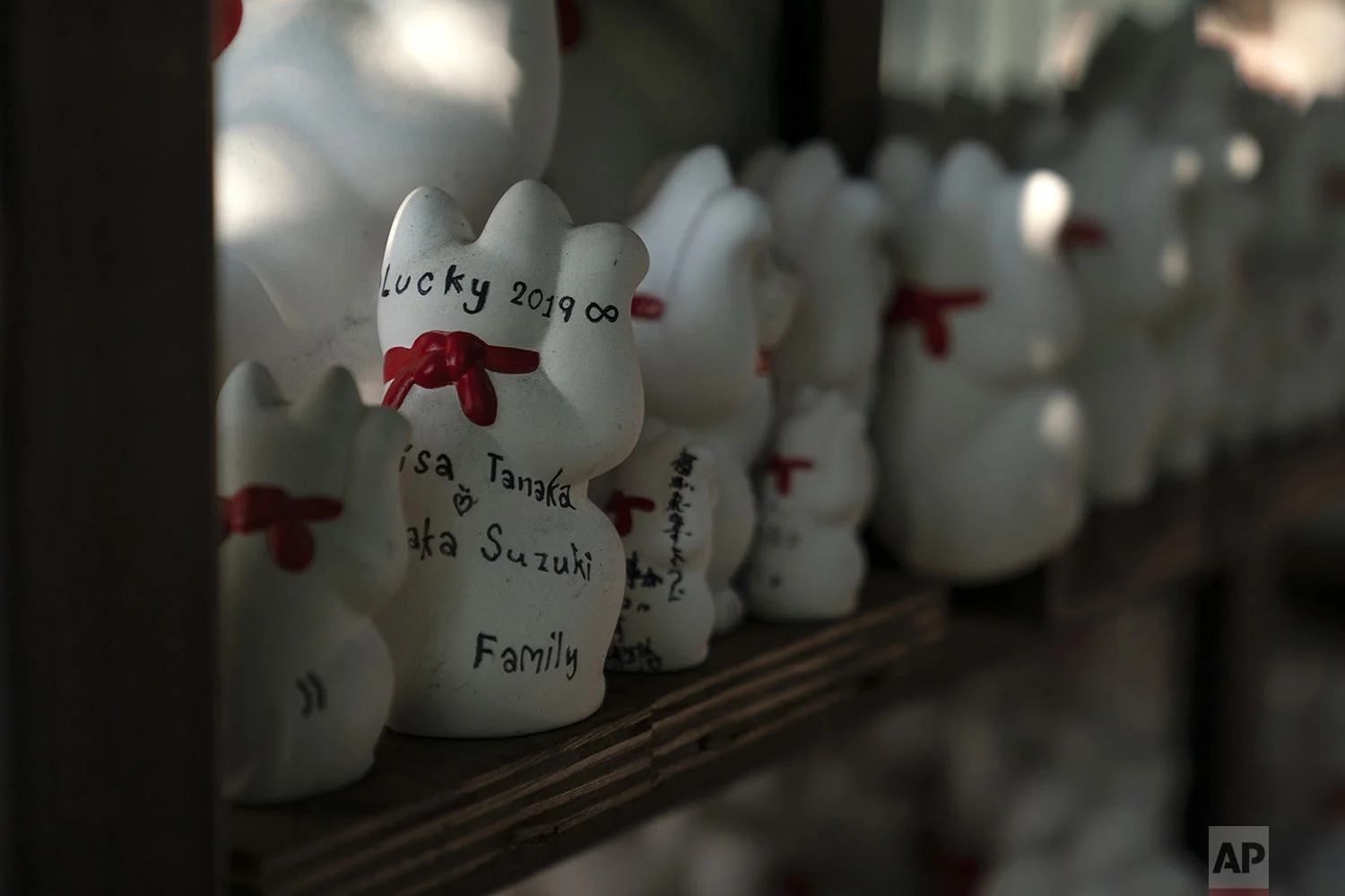 Messages are written on the back of beckoning cat figurines at Gotokuji Temple in Tokyo, Tuesday, June 25, 2019. (AP Photo/Jae C. Hong)