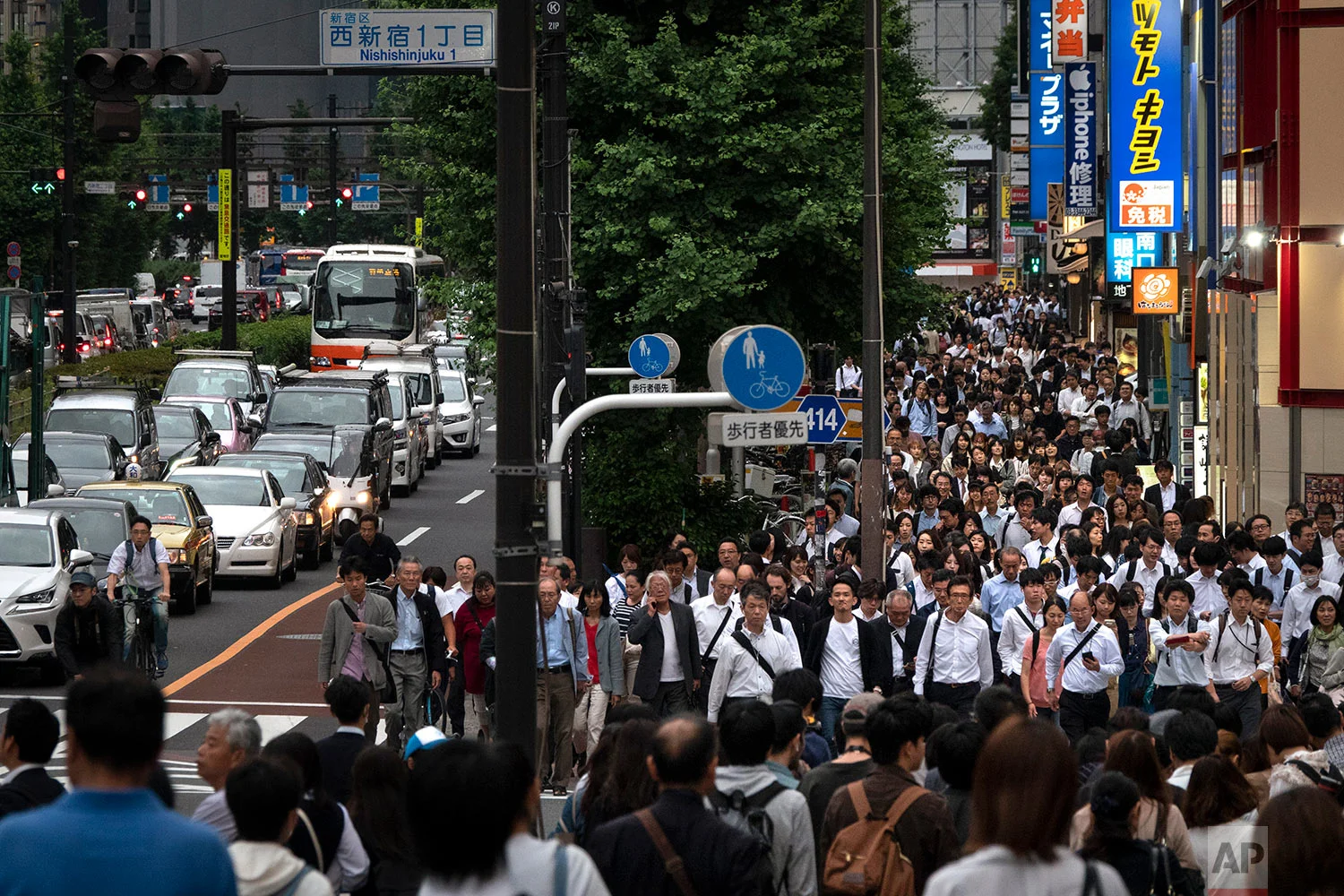 Commuters fill the street during the evening rush hours in the Shinjuku district of Tokyo, June 12, 2019. (AP Photo/Jae C. Hong)