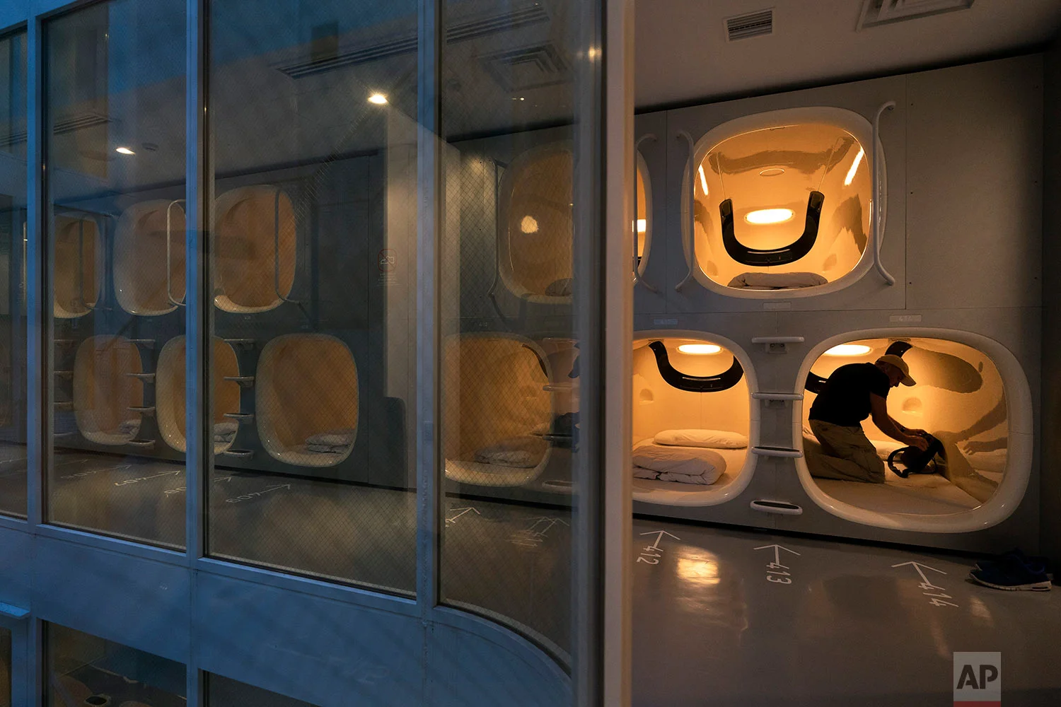 Laurent Colin, a 46-year-old tourist visiting from Australia, settles into his pod at the 9H capsule hotel in the Chiyoda district of Tokyo, May 30, 2019. (AP Photo/Jae C. Hong)