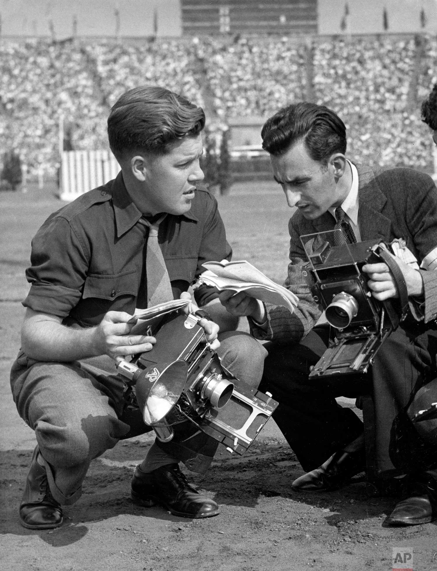 AP Boston photographer J. Walter Green, assigned to Rome, discusses coverage with AP London photographer Lawrence Harris at London's Wembley Stadium during the Summer Olympics, August 1948. (AP Photo)