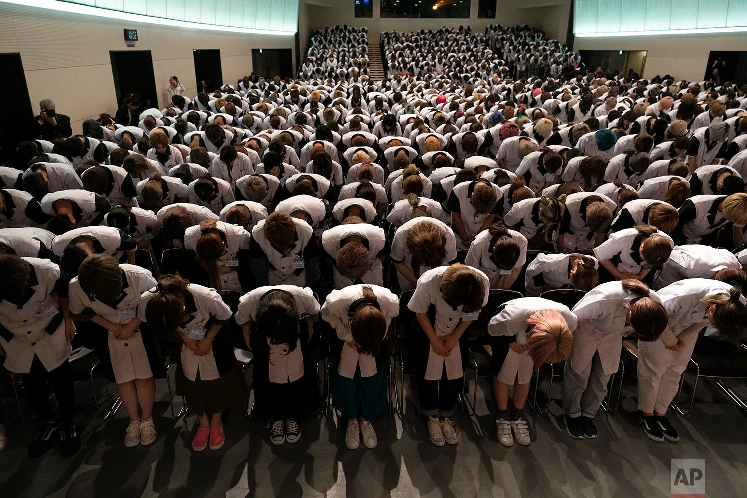 Wearing school uniforms, students at Yamano Beauty College bow to a speaker during a ceremony held to celebrate the school's 83rd year anniversary in Tokyo, May 31, 2019. More than 1200 students from all over Japan are attending the school to be hair stylists or makeup artists. (AP Photo/Jae C. Hong)