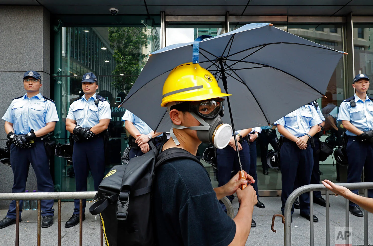 A protestor stands in front of a line of policemen outside the police headquarters in Hong Kong on June 21, 2019. (AP Photo/Vincent Yu)
