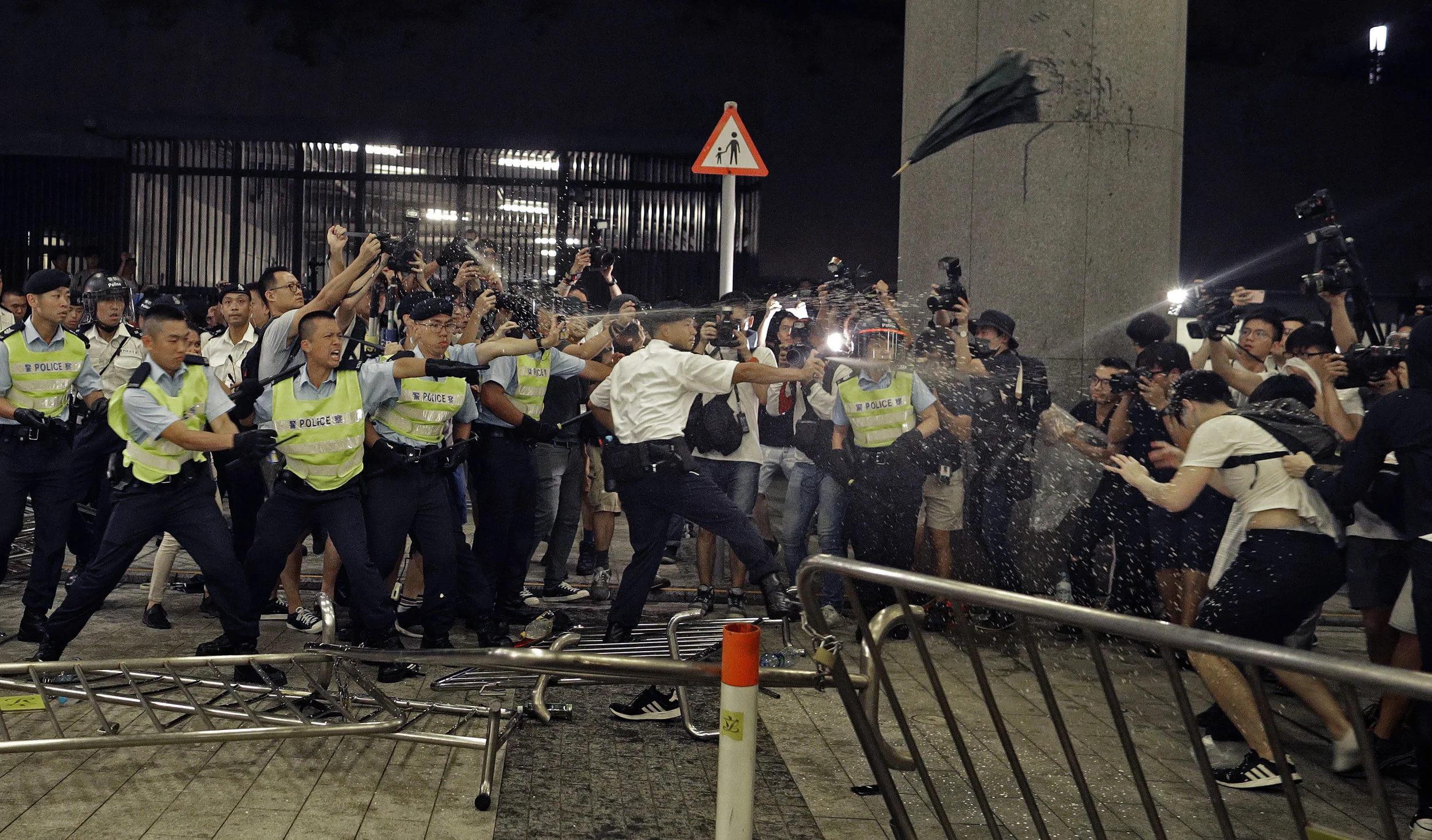 Police officers use pepper spray against protesters in a rally against the proposed amendments to the extradition law at the Legislative Council in Hong Kong on June 10, 2019. (AP Photo/Vincent Yu)