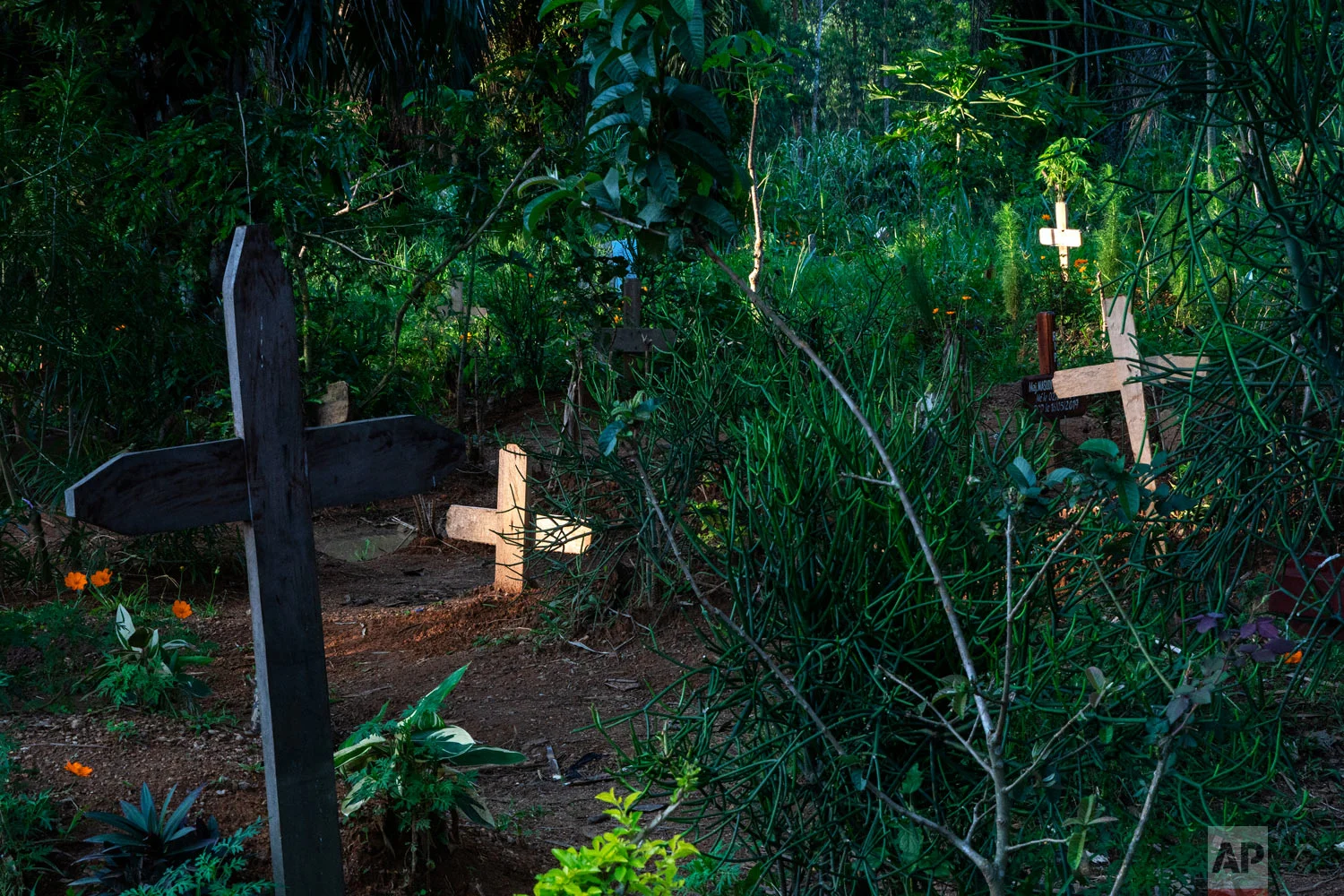 Light shines on freshly dug graves in Beni, Congo, July 16, 2019. (AP Photo/Jerome Delay)