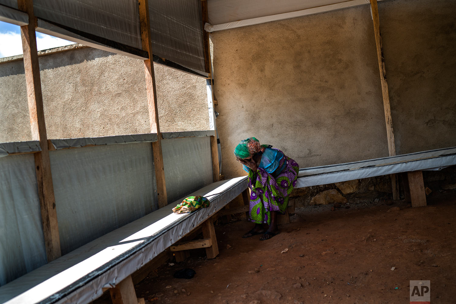 A woman waits at the morgue for the body of her relative to be cleared for burial in Beni, Congo, July 14, 2019. (AP Photo/Jerome Delay)