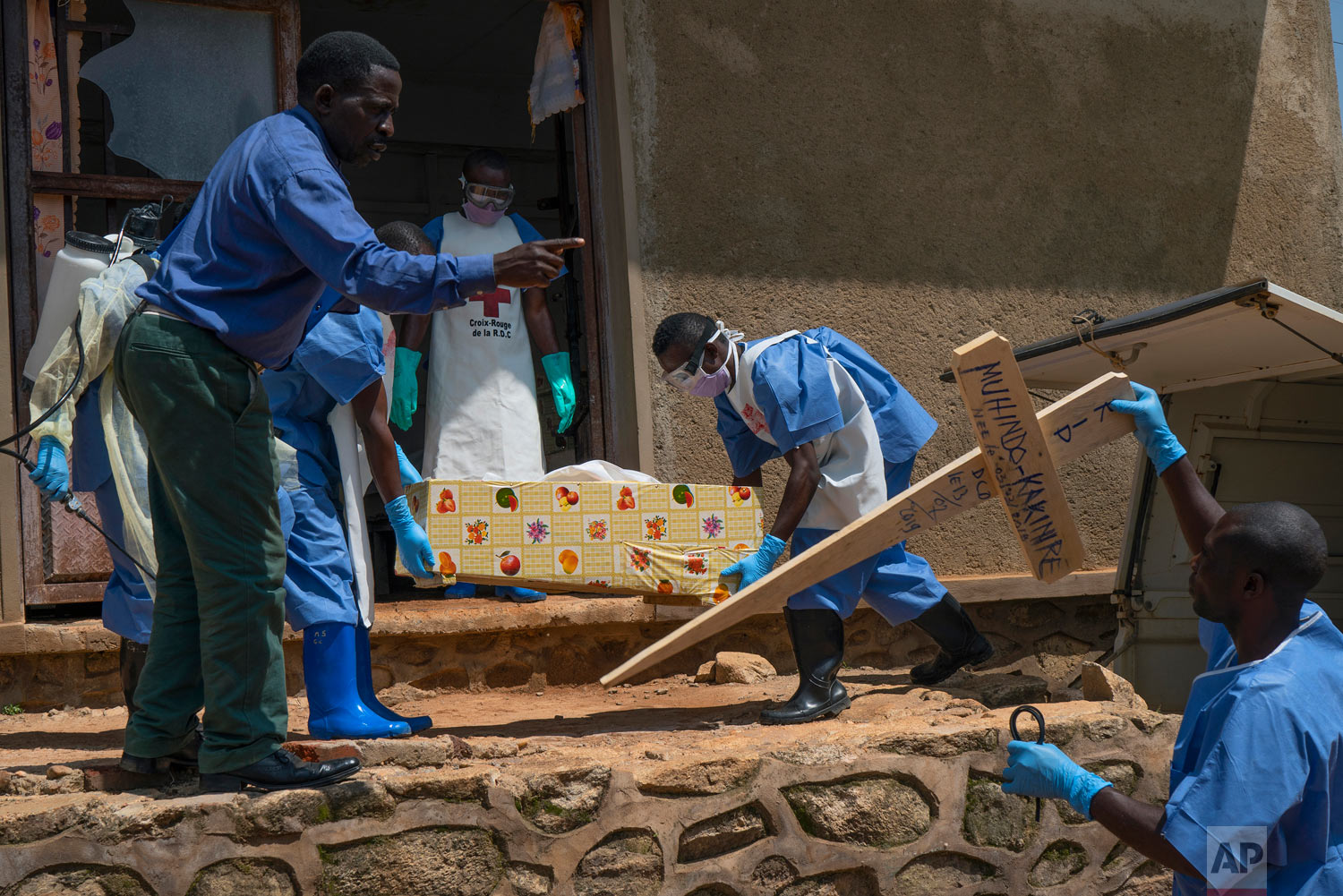 Red Cross workers carry the remains of 16-month-old Muhindo Kakinire from the morgue into a truck as health workers disinfect the area in Beni, Congo, July 14, 2019. (AP Photo/Jerome Delay)