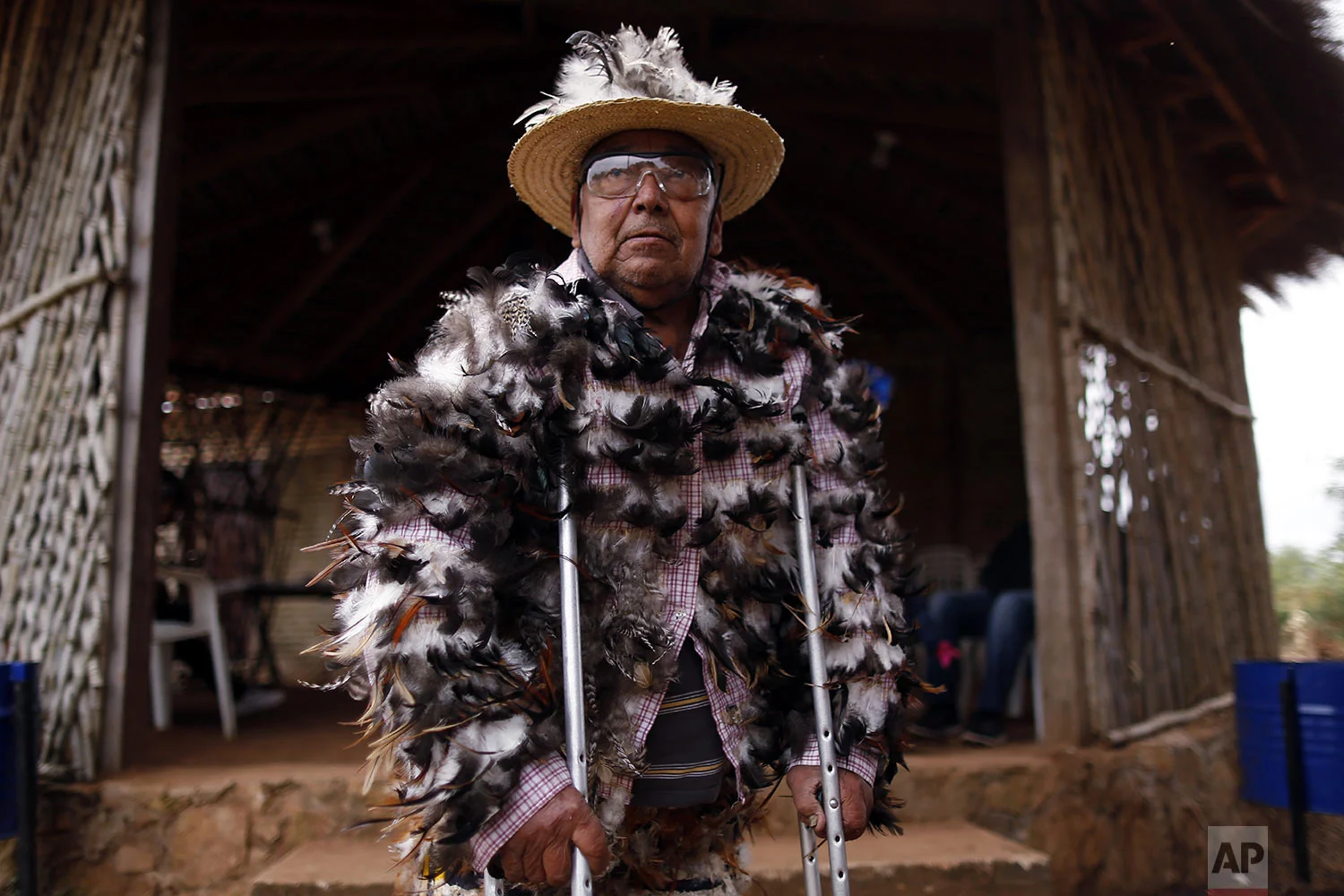 Pedro Balbuena, a 71-year-old chapel musician, poses for a portrait dressed in his feathered costume during the St. Francis Solano festival, in Emboscada, Paraguay, Wednesday, July 24, 2019. (AP Photo/Jorge Saenz)