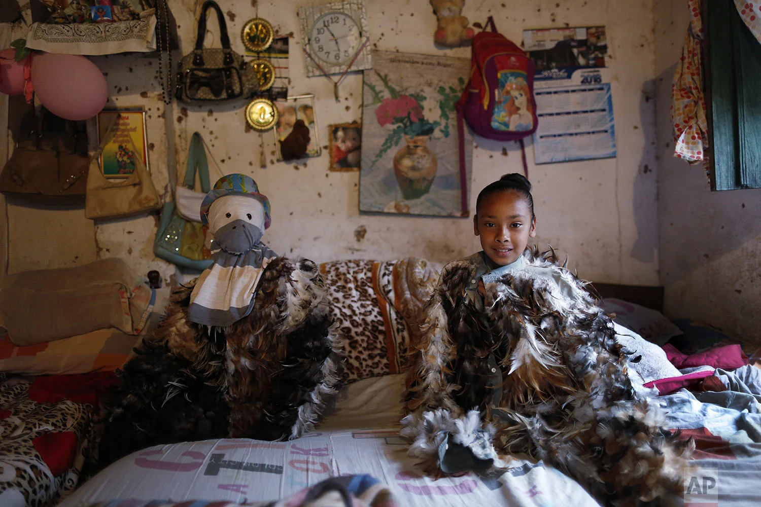  Alexis Aguero, left, and his sister Andrea sit in their bedroom dressed in their feathered costumes before they go to honor St. Francis Solano in Emboscada, Paraguay, Wednesday, July 24, 2019. (AP Photo/Jorge Saenz) 