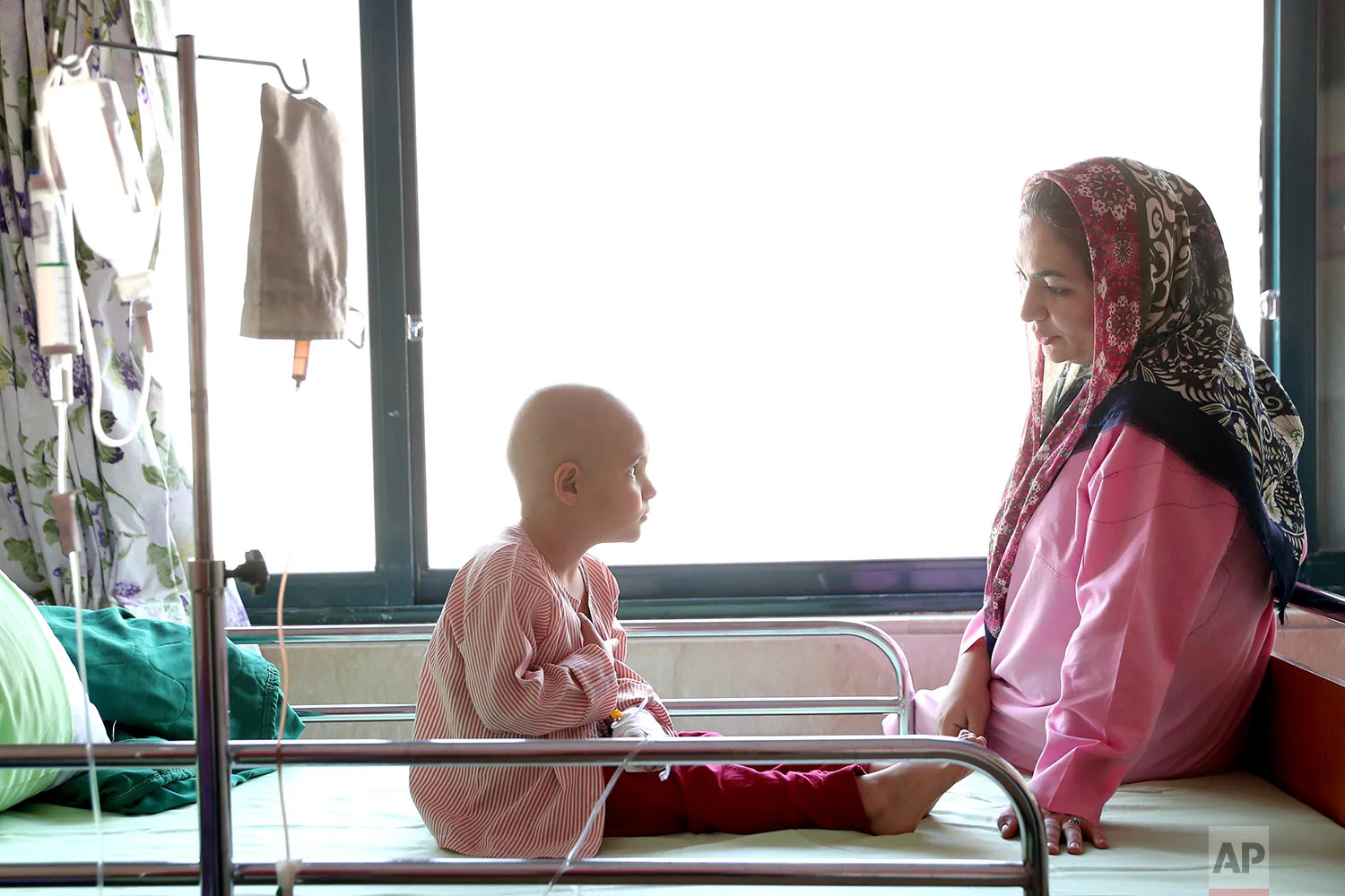 Parsa Amini, a 5-year-old boy suffering from eye cancer, speaks with his mother at Mahak Center's Hospital, in Tehran, Iran. (AP Photo/Ebrahim Noroozi)