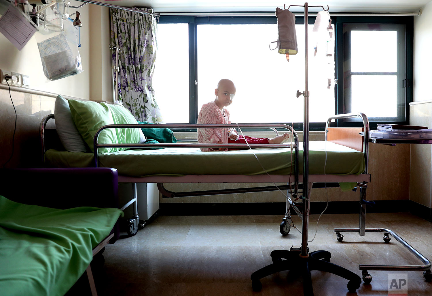 Parsa Amini, a 5-year-old boy suffering from eye cancer, sits on his bed at Mahak Children’s Hospital, in Tehran, Iran. (AP Photo/Ebrahim Noroozi)