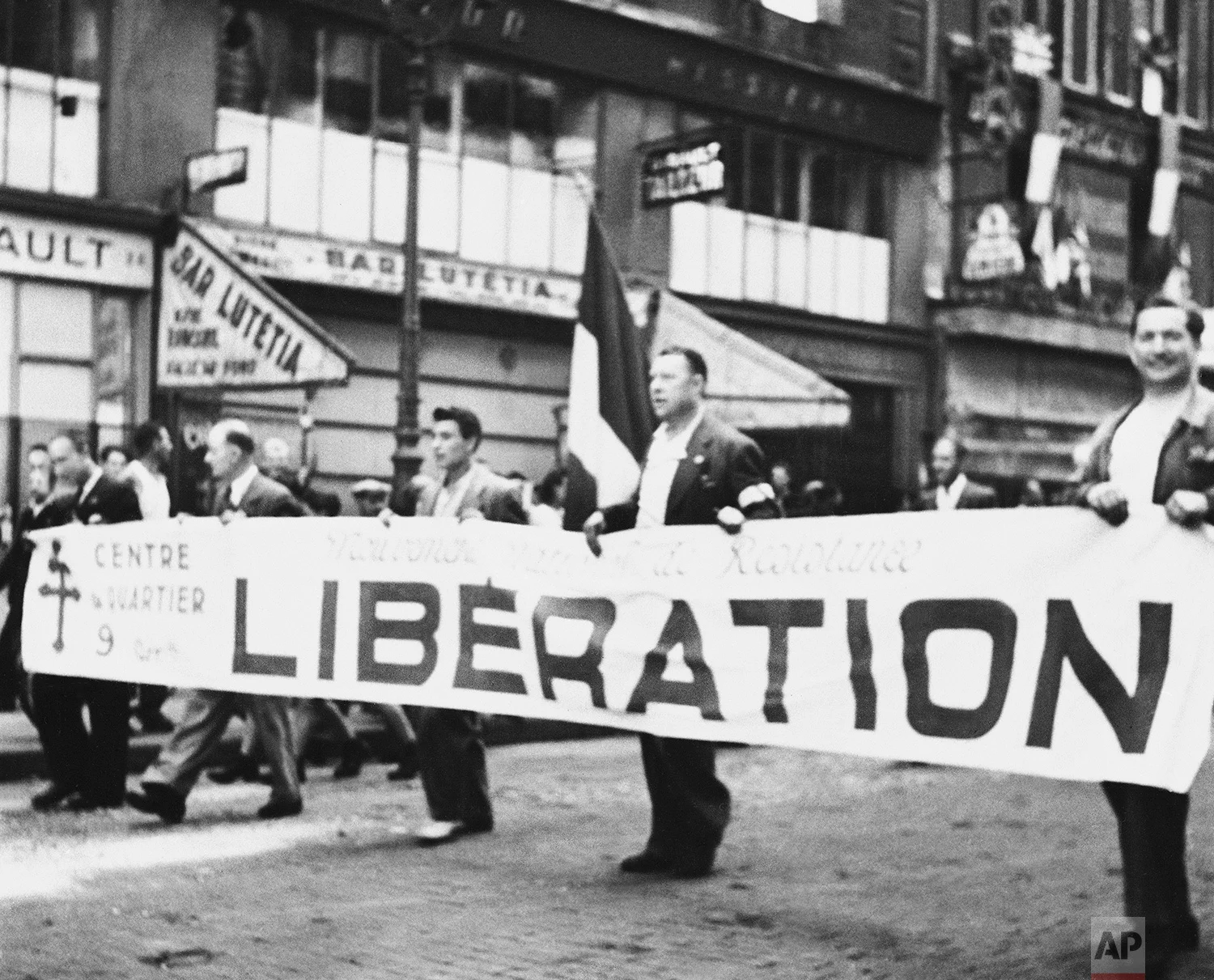 Carrying a huge banner proclaiming the liberation of Paris, men of the Maqui march through the city’s streets in Paris on August 28, 1944. Their jubilitation was a bit hasty, however, for peace has not yet come to liberated Paris. Mopping up of snipers continues, with the job of restoring order in the French capital left to General De Gaulle. (AP Photo)