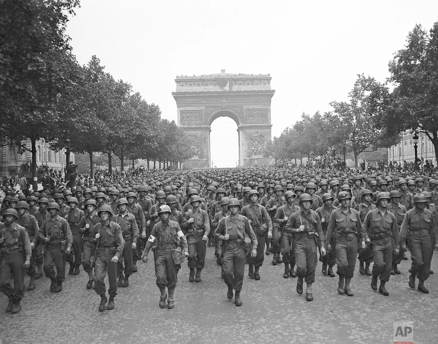 U.S. soldiers of Pennsylvania's 28th Infantry Division march along the Champs Elysees, the Arc de Triomphe in the background, on Aug. 29, 1944, four days after the liberation of Paris, France. World War II began in September 1939 with Adolf Hitler's invasion of Poland. He launched the Holocaust and history's most destructive war, leaving 17,000,000 soldiers and 60,000,000 civilians dead. Germany surrendered on May 7, 1945. (AP Photo/Peter J. Carroll)