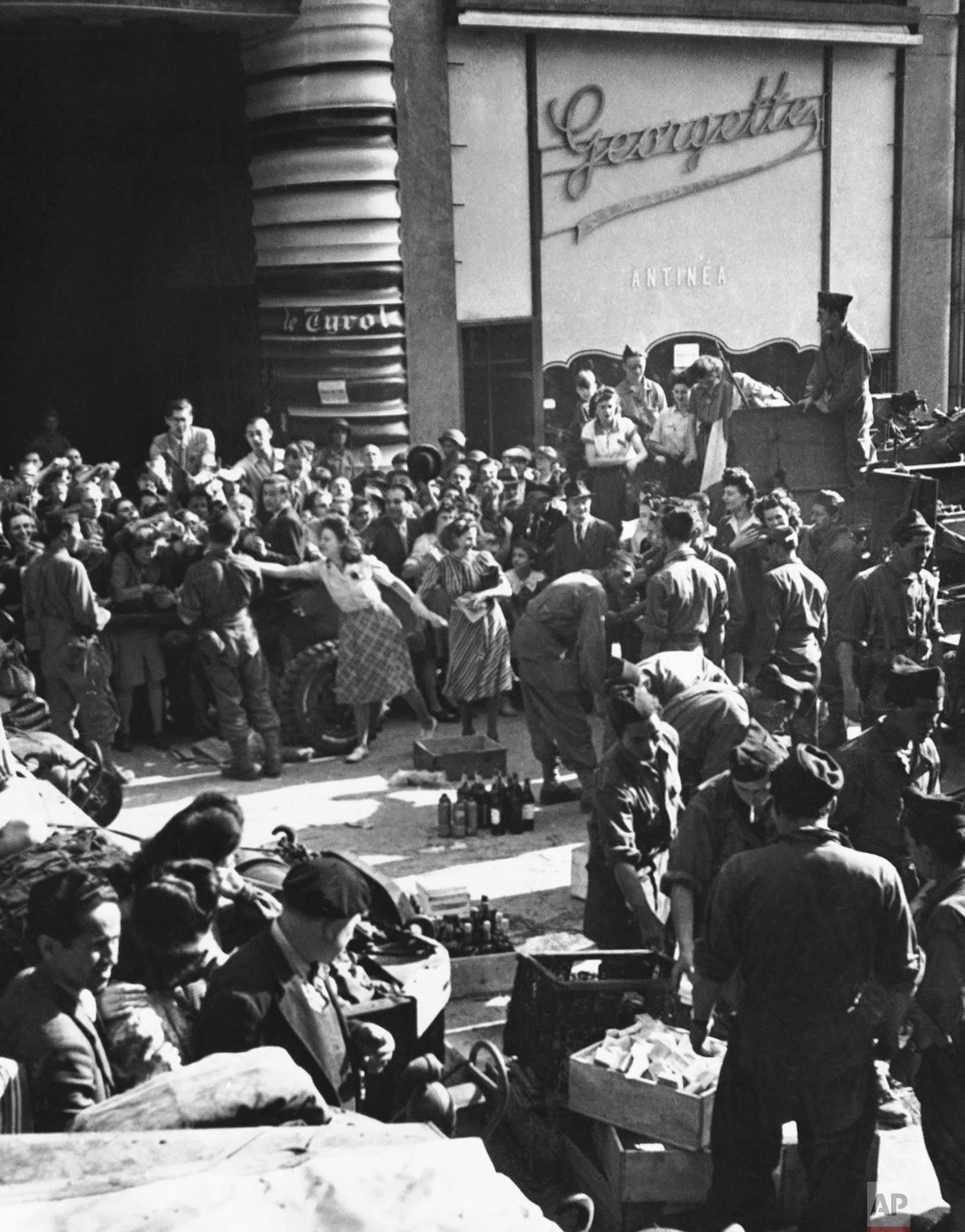 Precious liquor, saved for the day of Paris’ freedom, is carried from a wine store and passed out to French troops, Maquis and jubilant civilians following the liberation of the French capital in Paris on August 25, 1944. (AP Photo/Weston Haynes)
