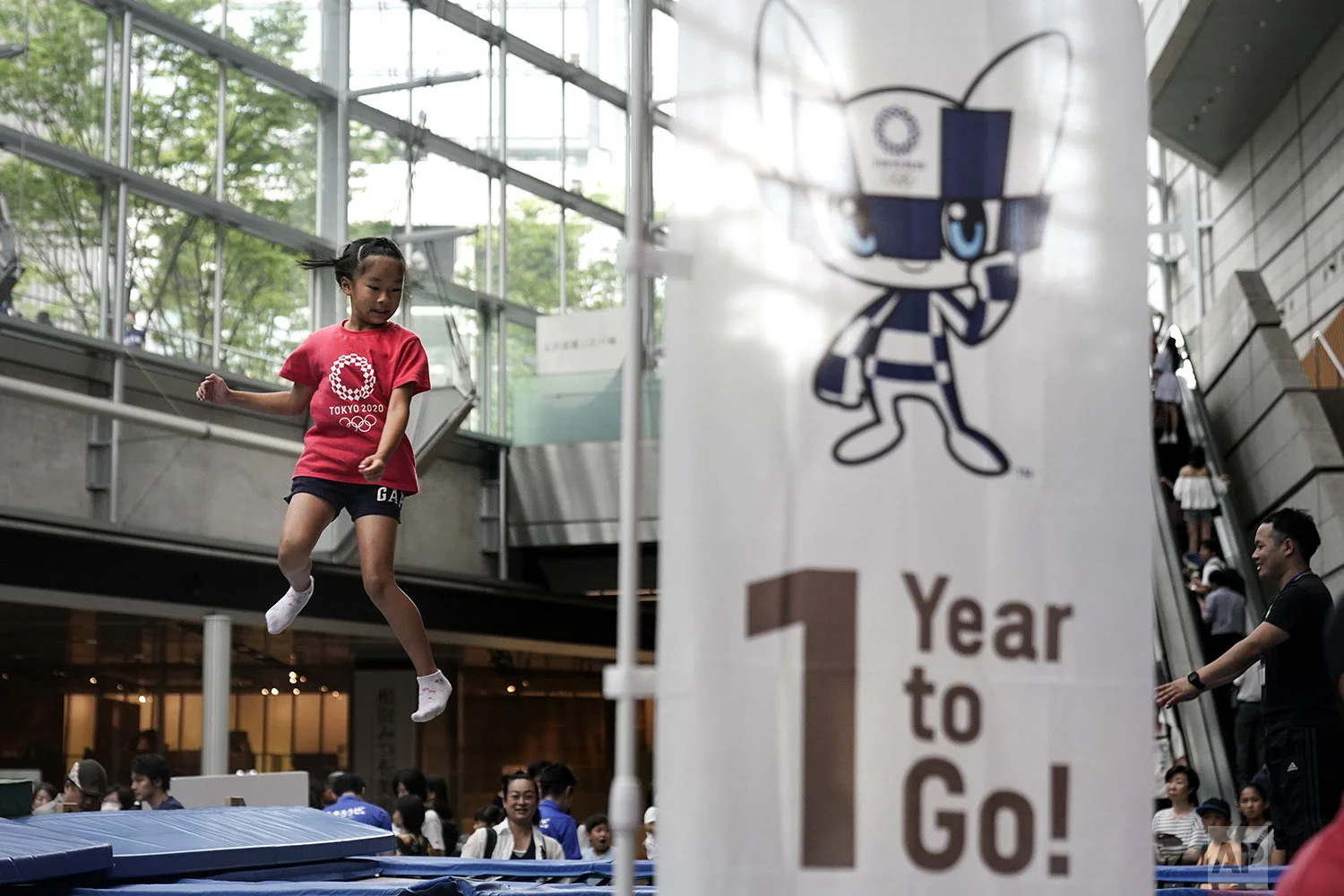 A girl plays on a trampoline during a One Year to Go ceremony held at Tokyo International Forum to mark one year until the opening of the Tokyo 2020 Olympics, in Tokyo, July 24, 2019, photo. (AP Photo/Jae C. Hong)