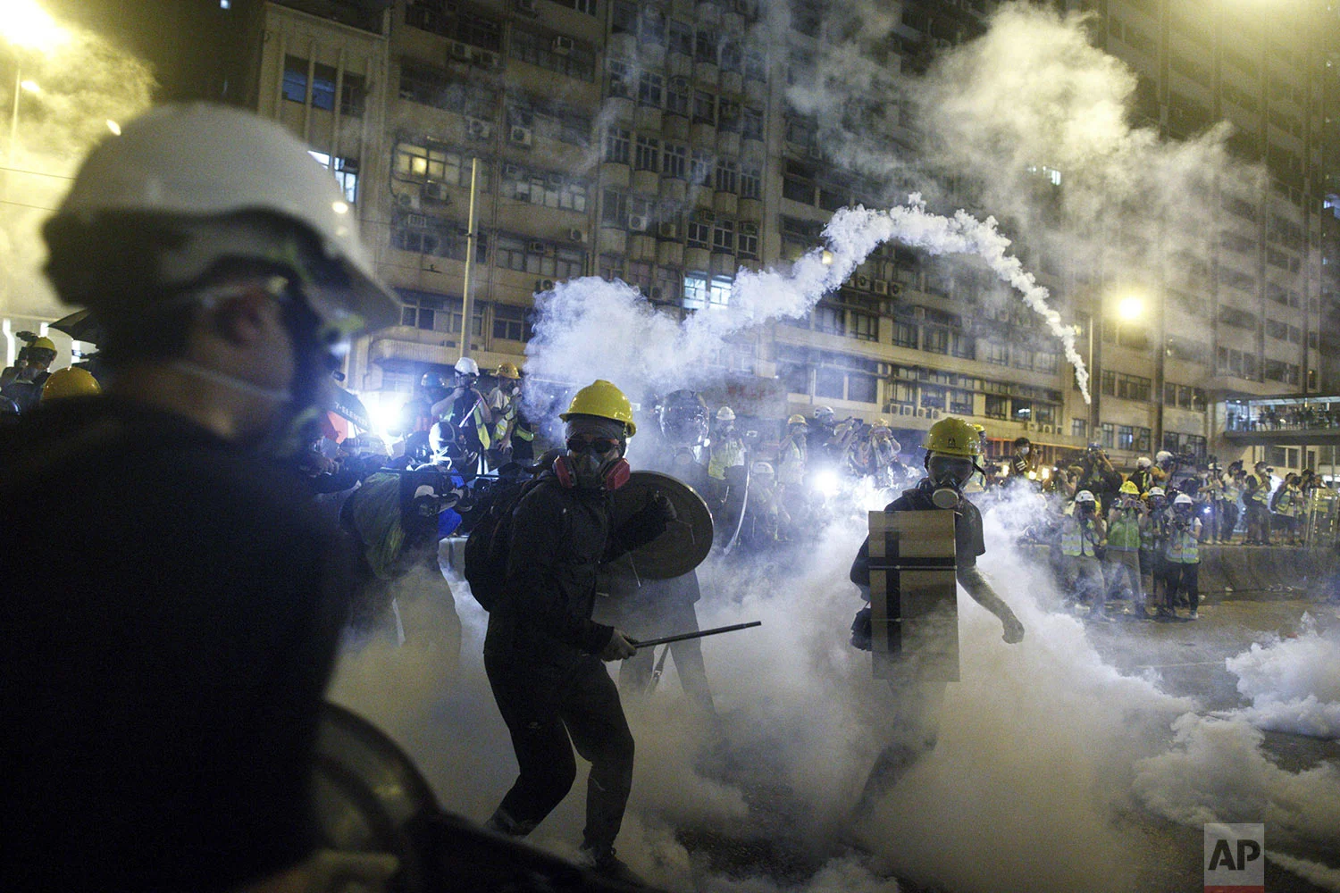 Protesters react to tear gas during a confrontation with riot police in Hong Kong, July 21, 2019. (Eric Tsang/HK01 via AP)