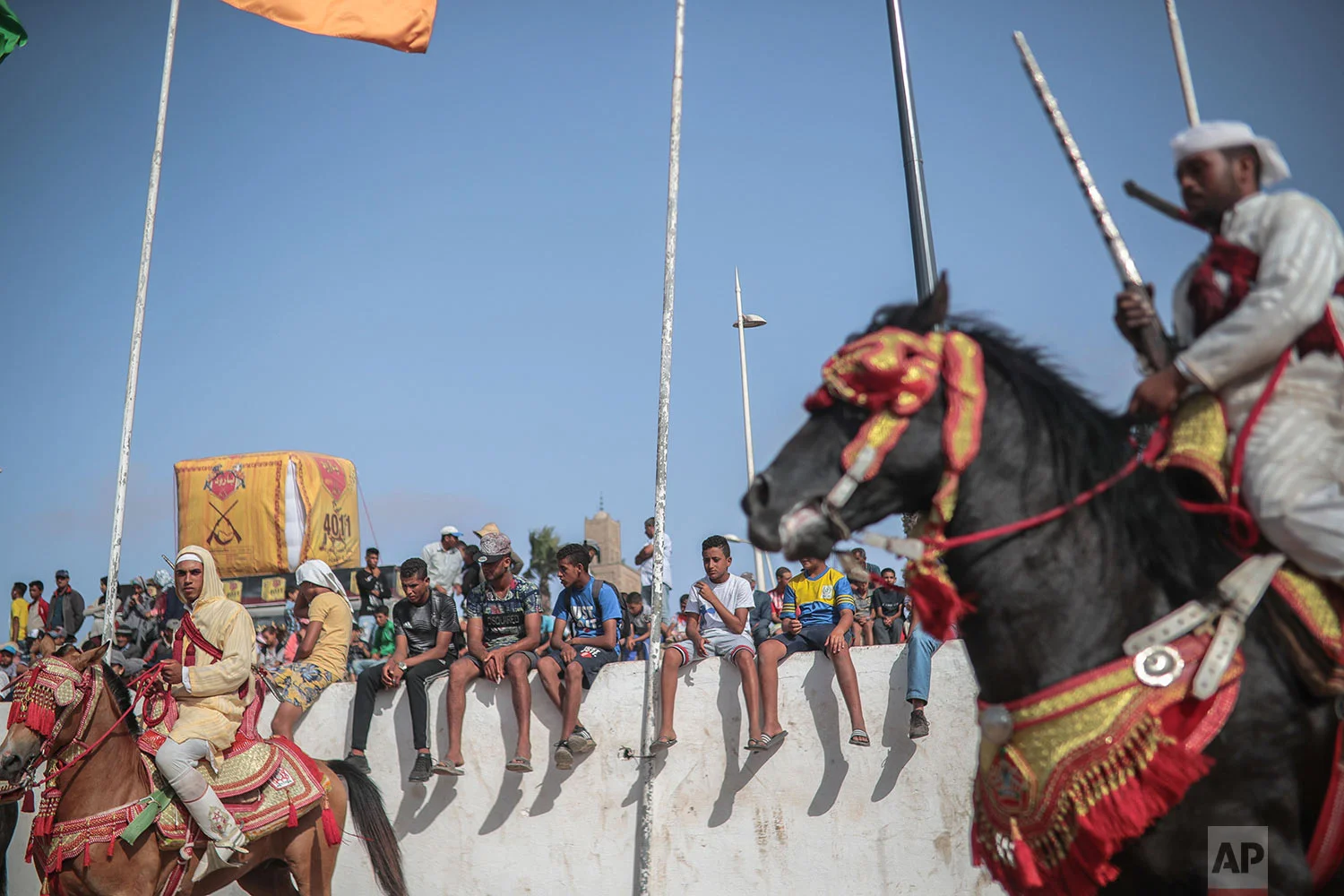 People watch as riders wait during Tabourida, a traditional horse riding show also known as Fantasia, in the coastal town of El Jadida, Morocco, July 25, 2019. (AP Photo/Mosa'ab Elshamy)