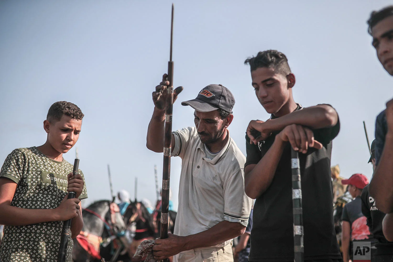 A man helps prepare rifles before being loaded with gunpowder to be used in Tabourida in the coastal town of El Jadida, Morocco, July 25, 2019. (AP Photo/Mosa'ab Elshamy)