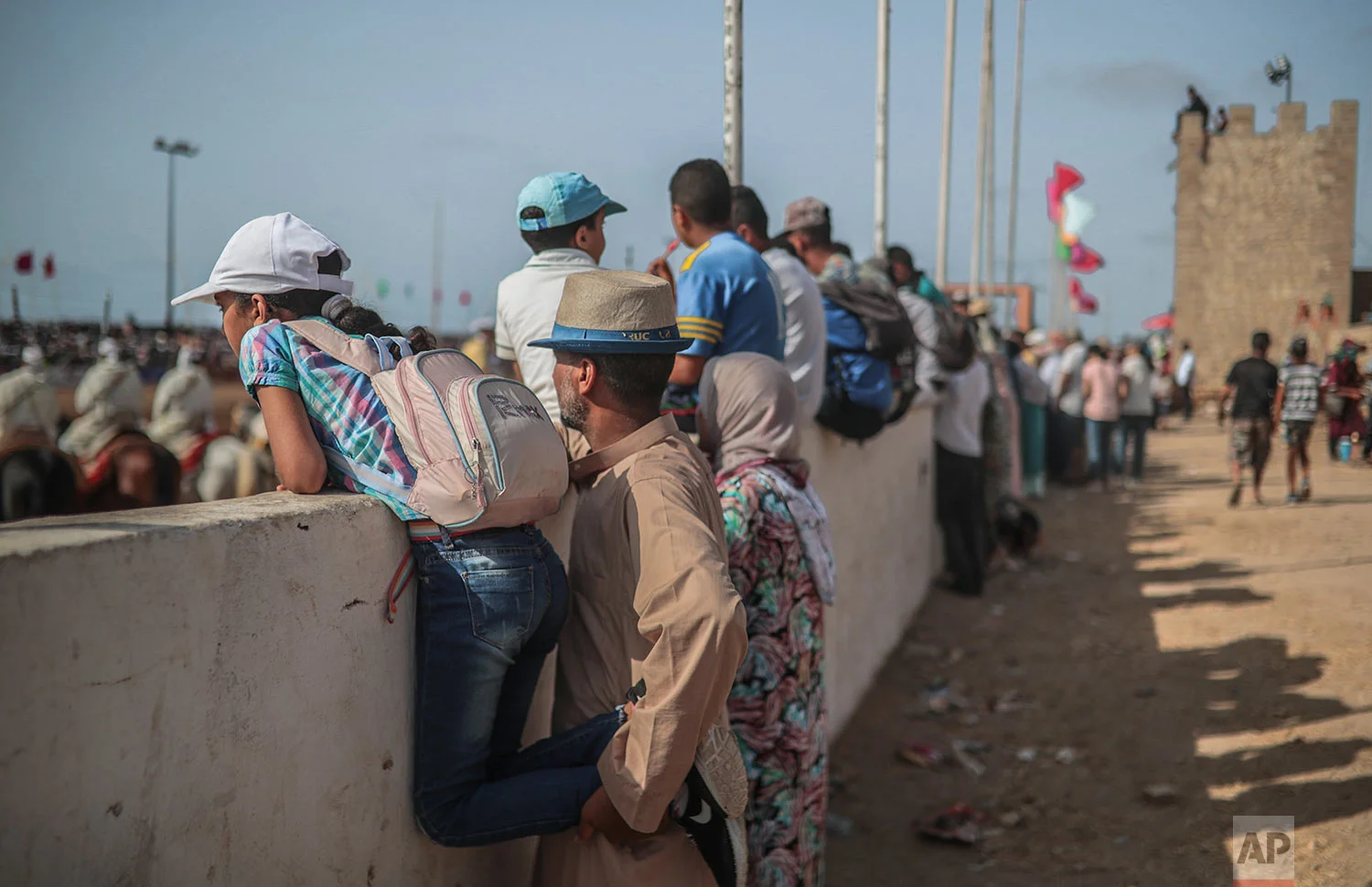 People watch Tabourida, a traditional horse riding show also known as Fantasia, in the coastal town of El Jadida, Morocco, July 25, 2019. (AP Photo/Mosa'ab Elshamy)