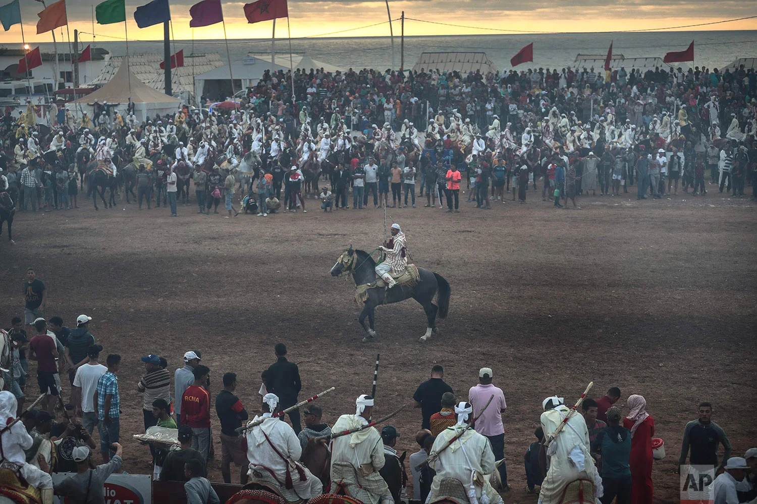 People watch as a rider takes part in Tabourida, a traditional horse riding show also known as Fantasia, in the coastal town of El Jadida, Morocco, July 25, 2019. (AP Photo/Mosa'ab Elshamy)