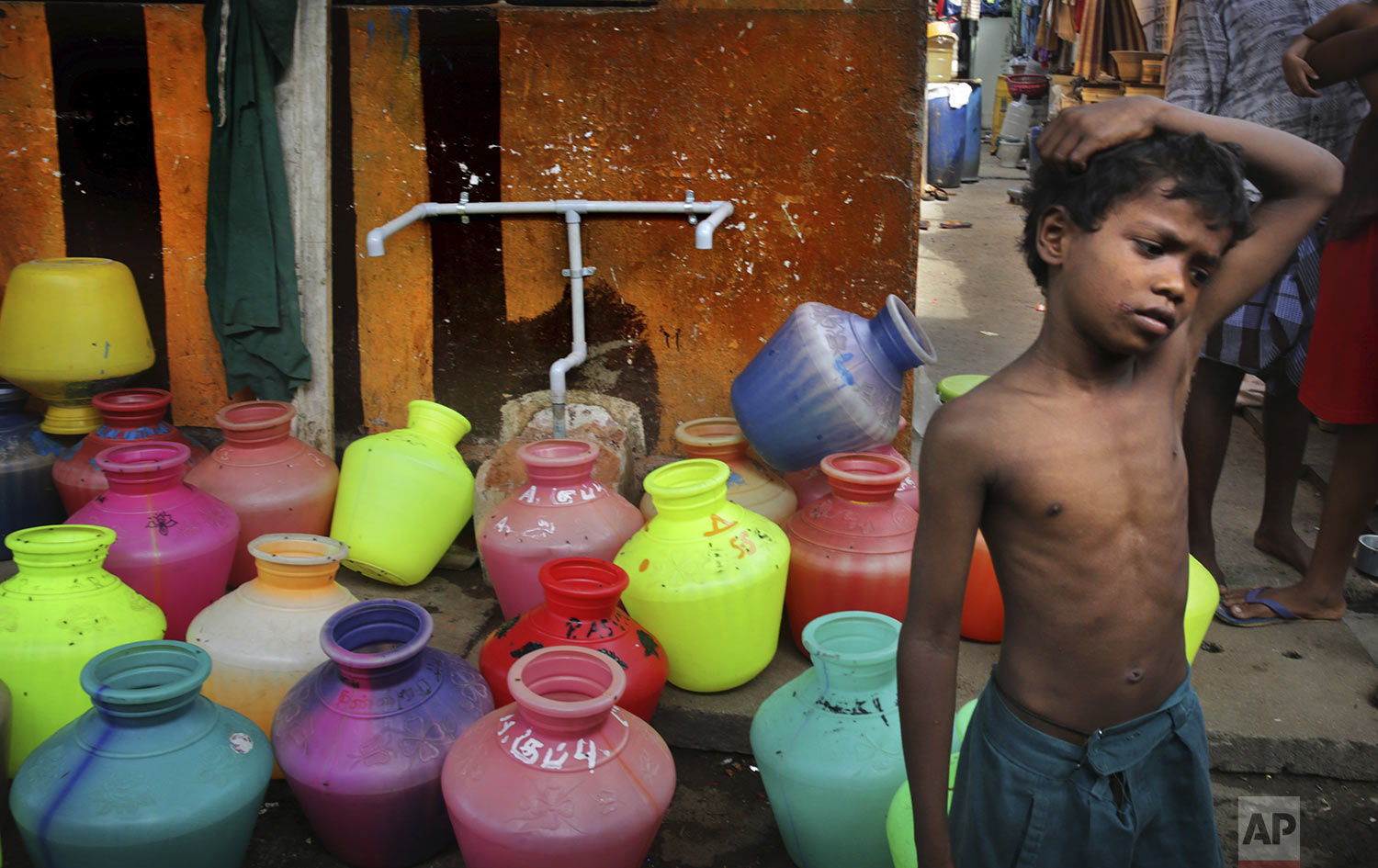 A boy waits at water assembly point in a locality in Chennai in Southern Indian state of Tamil Nadu, Thursday, July 18, 2019, photo. (AP Photo/Manish Swarup)