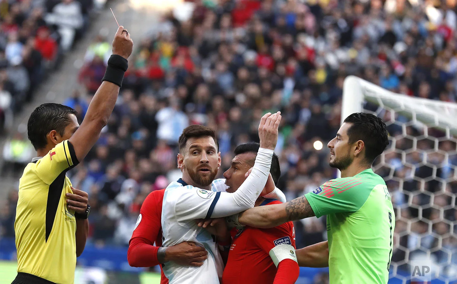 Argentina's Lionel Messi, center left, and Chile's Gary Medel, center right, scuffle as referee Mario Diaz, from Paraguay, left, shows the red card to both of them during Copa America third-place soccer match at the Arena Corinthians in Sao Paulo, Brazil, Saturday, July 6, 2019. (AP Photo/Victor R. Caivano)