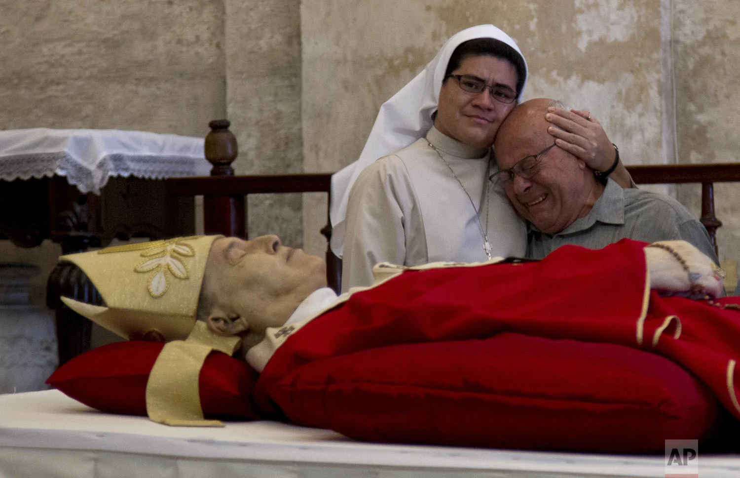 Reynol Alamino Ortega cries next to the body of his cousin, Cardinal Jaime Lucas Ortega y Alamino, during his wake inside the Cathedral in Havana, Cuba, Saturday, July 27, 2019. Ortega, a sugar worker's son who oversaw the first papal visit to Cuba, helped lower barriers to believers in the communist country and played a role in mediating improved U.S.-Cuba ties, died Friday at age 82. (AP Photo/Ismael Francisco)