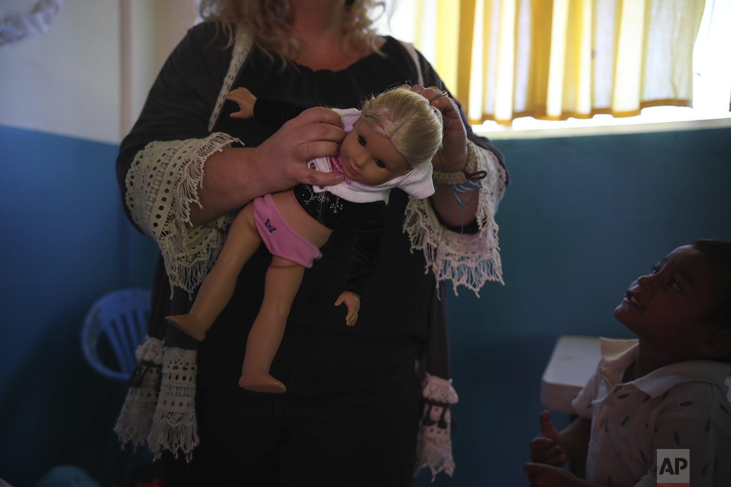  In this May 25, 2019 photo, Mindi Parish Stainer holds a doll during the baby shower for Salvadoran teen migrant Milagro de Jesus Henriquez Ayala, at a meeting hall in Tijuana, Mexico. Parish Stainer has been instrumental in getting the help the pre