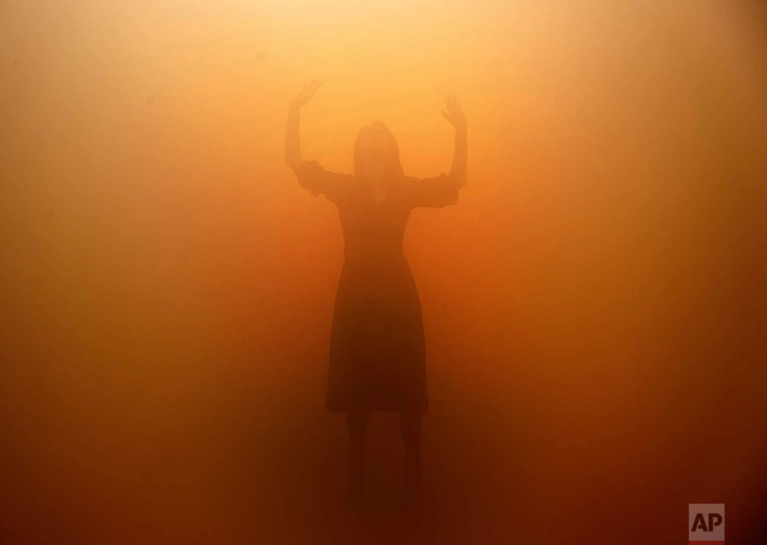 A visitor tries to orientate through a room full of fog called 'Your blind passenger' as part of the exhibition Olafur Eliasson: 'In real life' at the Tate Modern Gallery in London, Tuesday, July 9, 2019. The Tate Modern has brought together around 40 works of Eliasson spanning the last three decades, and are on display from July 11, 2019 until January 5, 2020. (AP Photo/Frank Augstein)