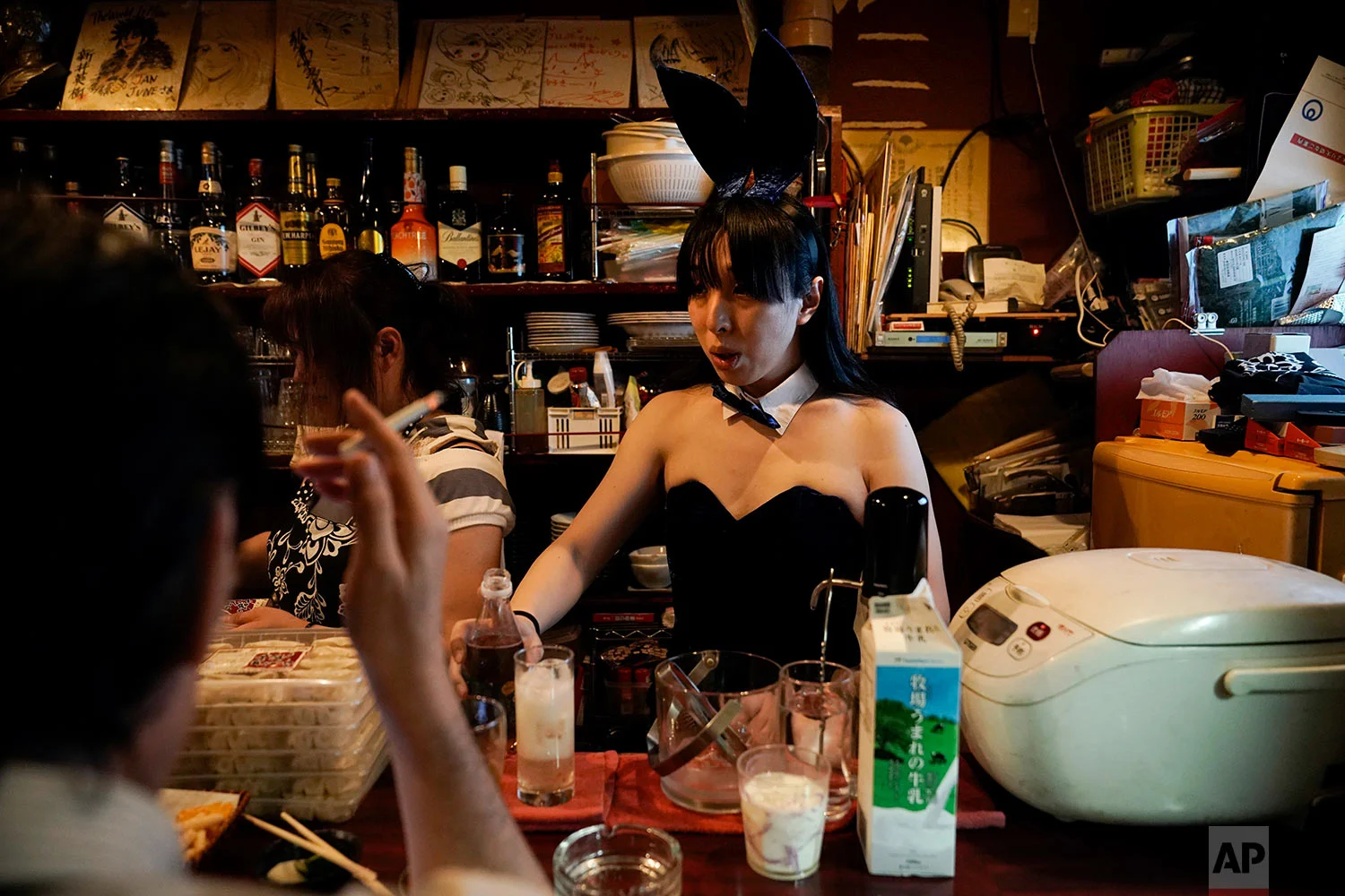 A bartender, in costume, prepares a drink for a patron in a bar at the Golden Gai in the Shinjuku district of Tokyo, July 26, 2019. (AP Photo/Jae C. Hong)