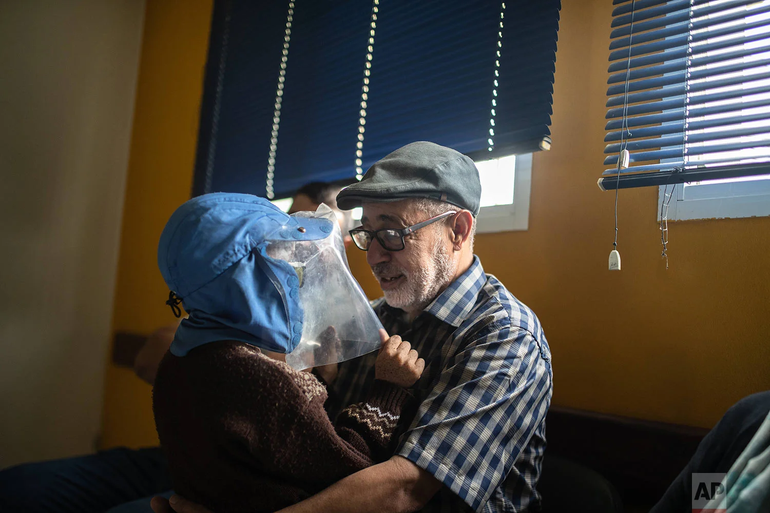 Habib El Ghazaoui, a father who runs the Association for Solidarity with Children of the Moon, plays with 8-year-old Mustapha who is affected by a rare genetic disorder called xeroderma pigmentosum, or XP, inside a hospital in Casablanca, Morocco, July 24, 2019. (AP Photo/Mosa'ab Elshamy)